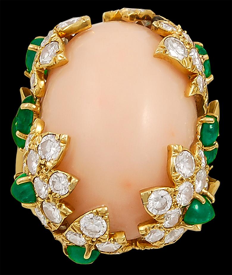 A 1980's vintage David Webb coral diamond and emerald ring and ear clip suite in 18k gold; each designed with a cabochon angel skin coral enclosed in a floral pave-set diamond and emerald setting.

Ring size 5 1/2.

Signed David Webb.
