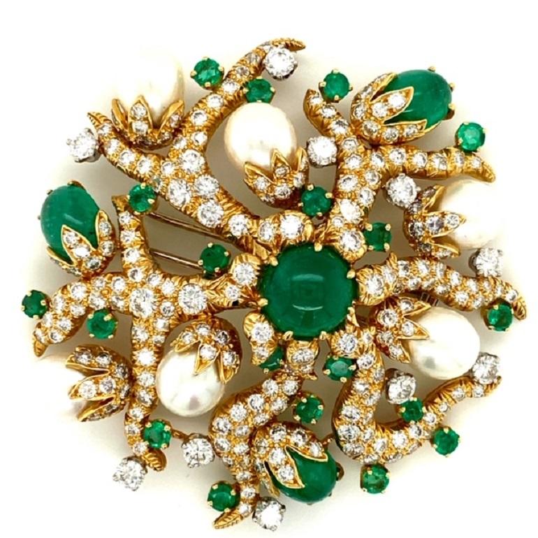 This modern David Webb double clip brooch from the Cross River collection contains 4 cabochon emeralds and 19 circular cut emeralds totaling approximately 17cts with an estimated 9cts of round brilliant diamonds.  It displays, a branching, root-like