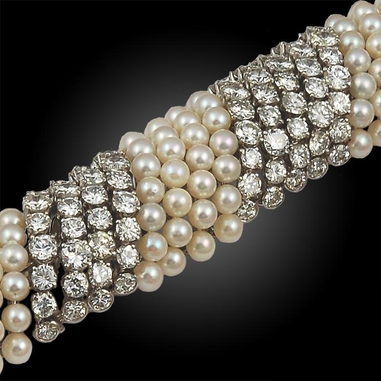 An elegant and stylish David Webb bracelet comprised of 18k platinum gold designed with spiraling rows of stunning pearls that intertwine with rows of radiant brilliant-cut diamonds. A timeless piece that adds glamour to the wrist. 
Signed David