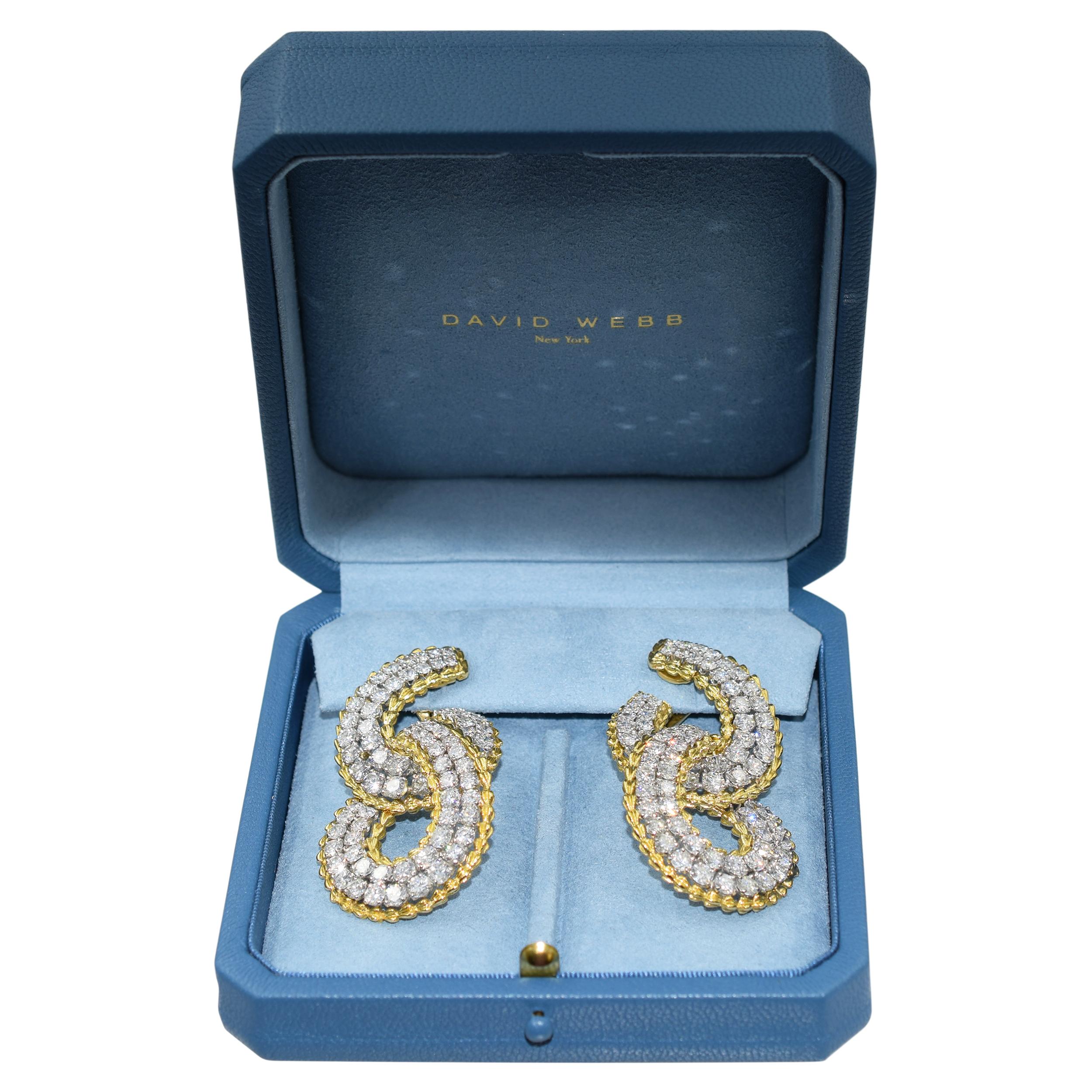 David Webb diamond drop earrings crafted in 18k yellow gold and platinum.
Each of these earrings consists of two loops connected together. Center of the loops set with two rows of diamonds accelerating in size, prong set in platinum, accented by