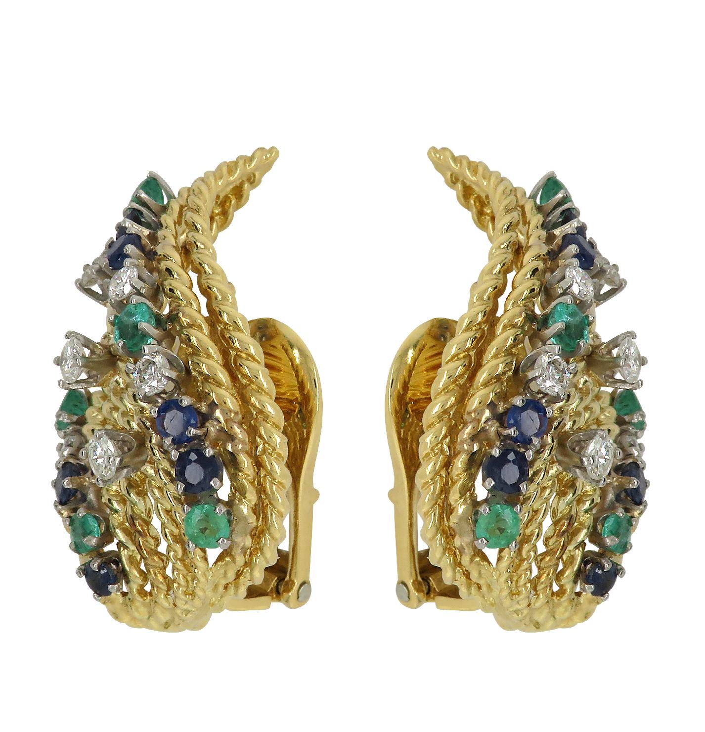 Enchanting David Webb clip-on earrings crafted in 18 karat yellow and white gold, featuring twisted gold strands detailed with emeralds, sapphires and diamonds. The strands leap up the ear in an elegant display of rich color and texture. The