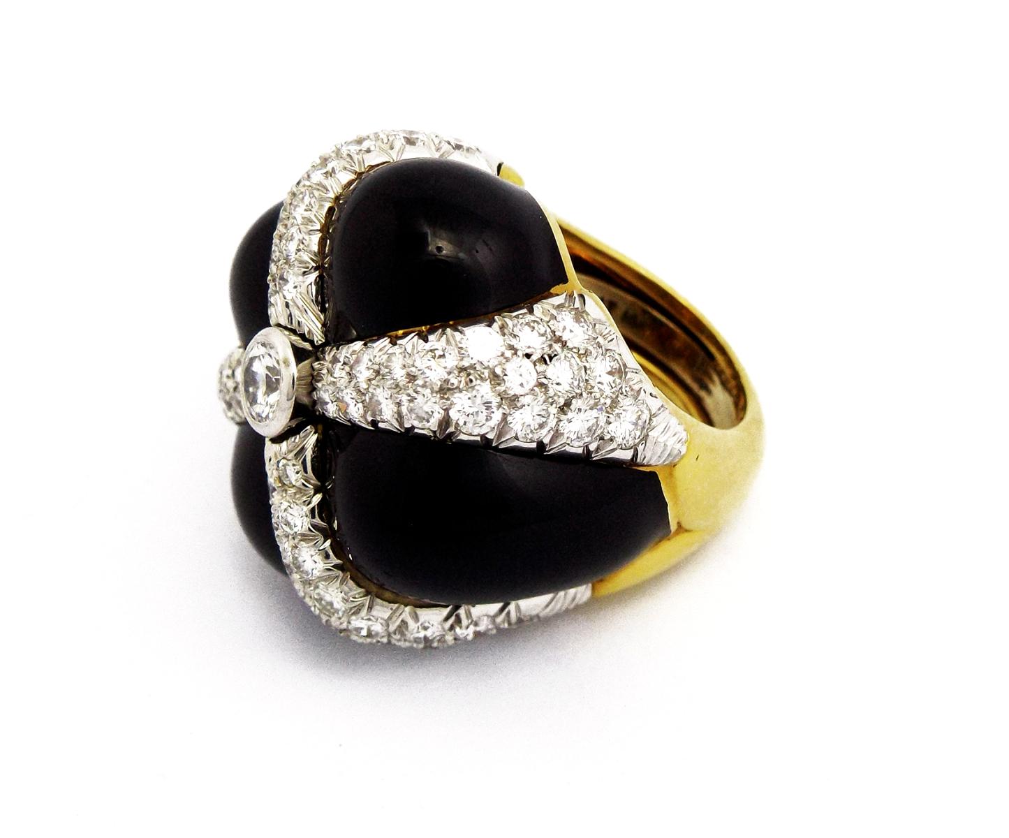 Of bombé design, the alternating black enamel plaque, with circular-cut diamond detail, centering upon a collet-set circular-cut diamond, ring size 6 1/4, has an inner horse shoe for easy downsizing, mounted in platinum and 18k gold. Signed Webb for