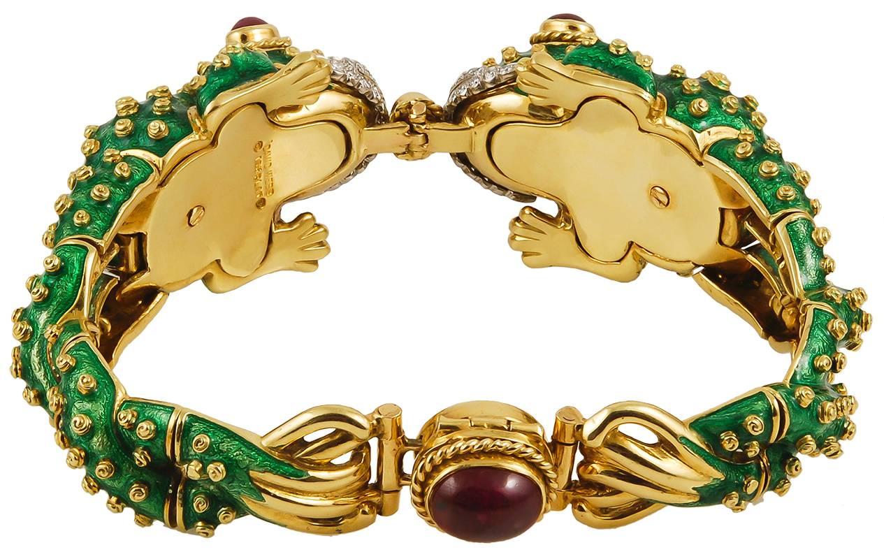 A 1960's David Webb frog bracelet, designed as an articulated hinged bangle modeled as two textured green enamel facing frogs with circular-cut diamond stylized lips and cabochon ruby eyes, with each gold-spotted body forming the remaining bracelet.