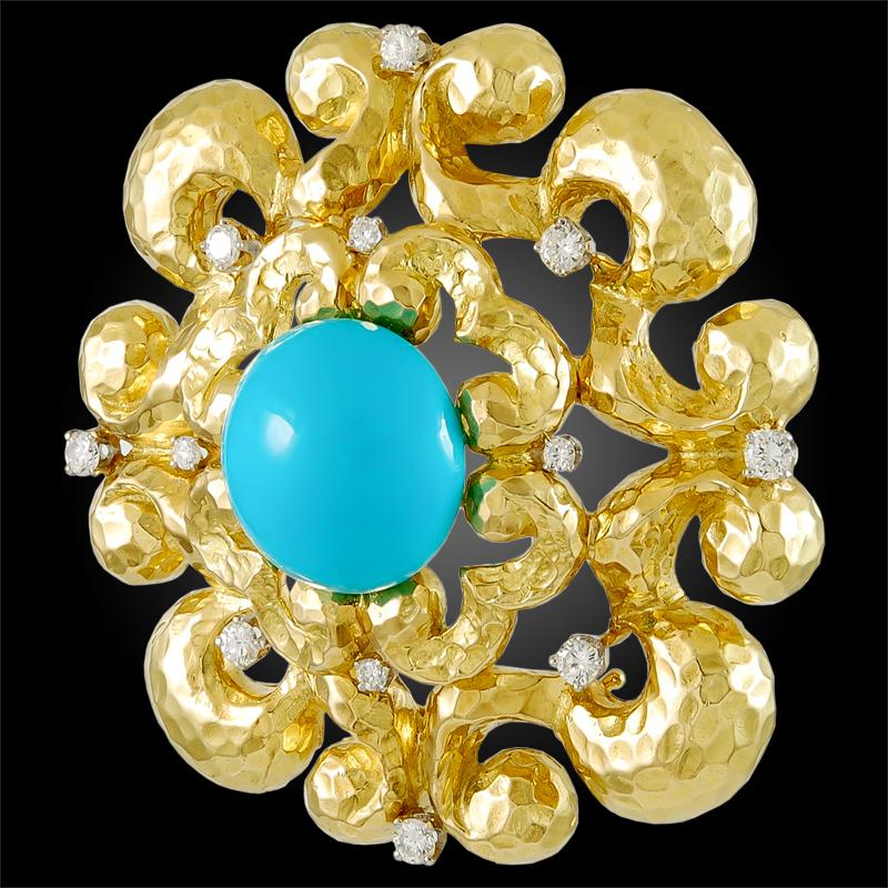 A remarkable brooch pendant by David Webb centering a large resplendent cabochon turquoise framed by 18k yellow gold hammered texture arabesques accentuated with round-cut diamonds throughout.
Signed David Webb.