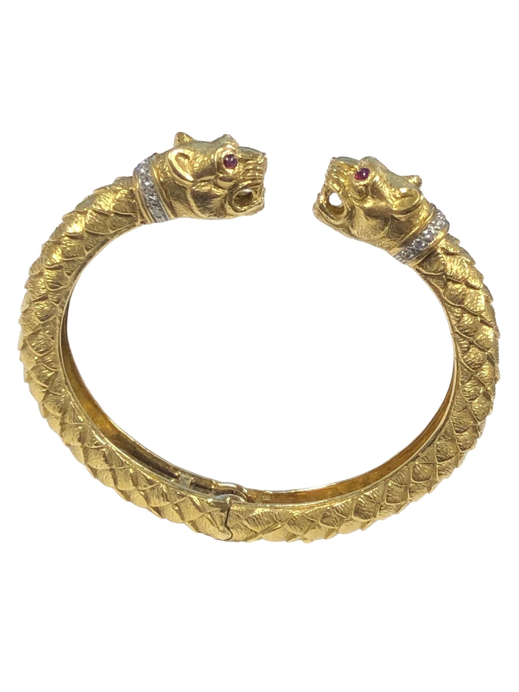 Circa 1980s David Webb Iconic Double Leopard, Chimera Heads 18k Yellow Gold Cuff bracelet, 3/8 inch wide, Hand Textured and Detailed with cabochon Ruby Eyes and Diamond set Collars. Il est articulé et s'adapte à des poignets de 6 1/4 à 7 1/2 pouces. 