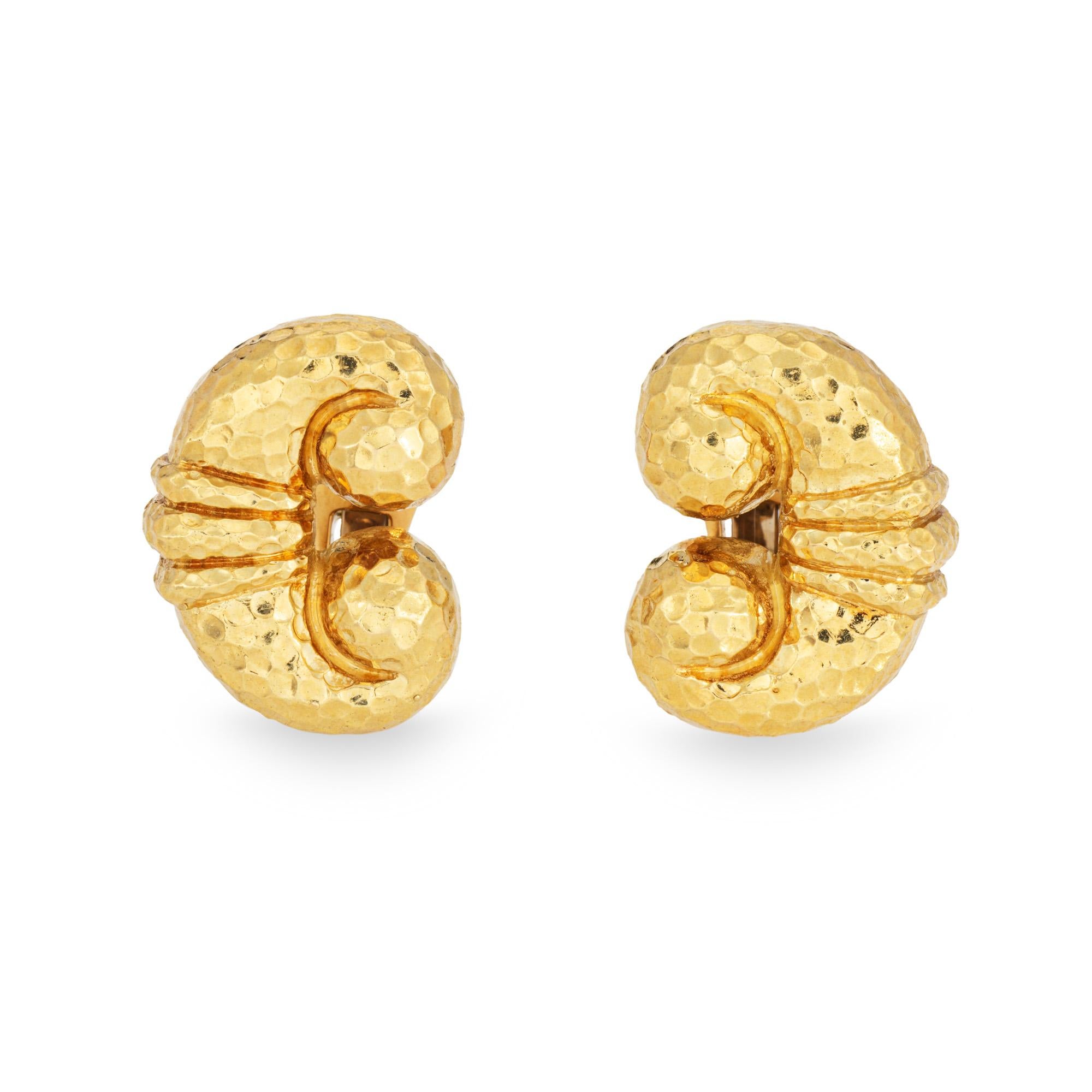 Vintage David Webb earrings crafted in 18 karat yellow gold (circa 1970s).  

The beautiful earrings highlight a scrolled design with hand hammered details. The bright and buttery 18k gold earrings catch light and shimmer with a subtle glow. A chic