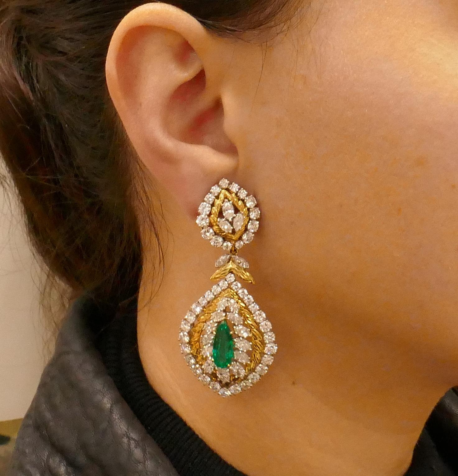 Stunning Day & Night Cross River earrings. Feature elongated pear cut emeralds surrounded with diamonds set in 18 karat yellow gold and platinum. 
The emeralds are approximately 3.05-carat and 2.75-carat. The diamonds are round brilliant and