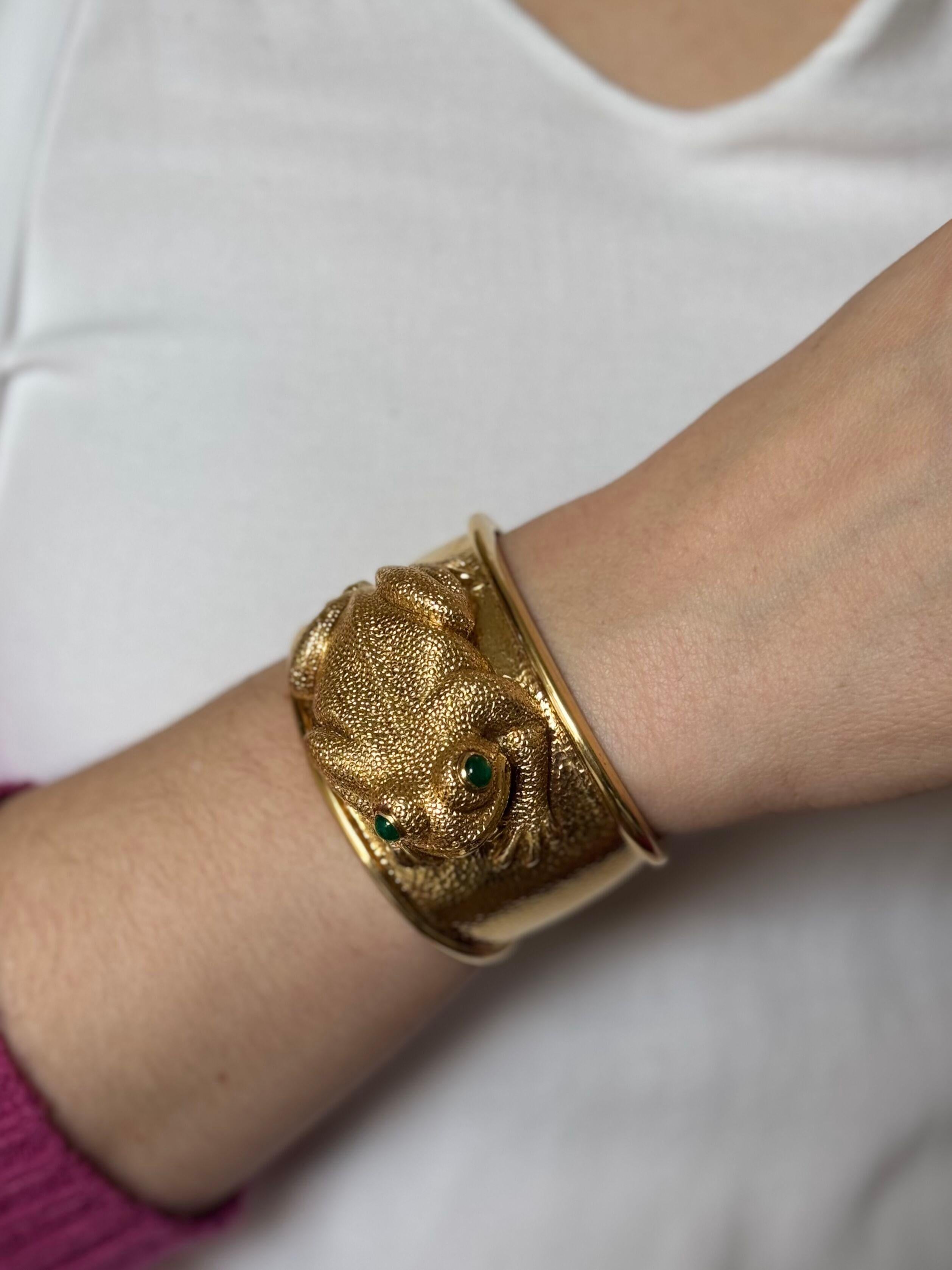 Bracelet manchette iconique en or jaune 18k de David Webb, représentant une grenouille avec des yeux en cabochon d'émeraude.
Le bracelet s'adapte à un bracelet de taille moyenne, environ 7