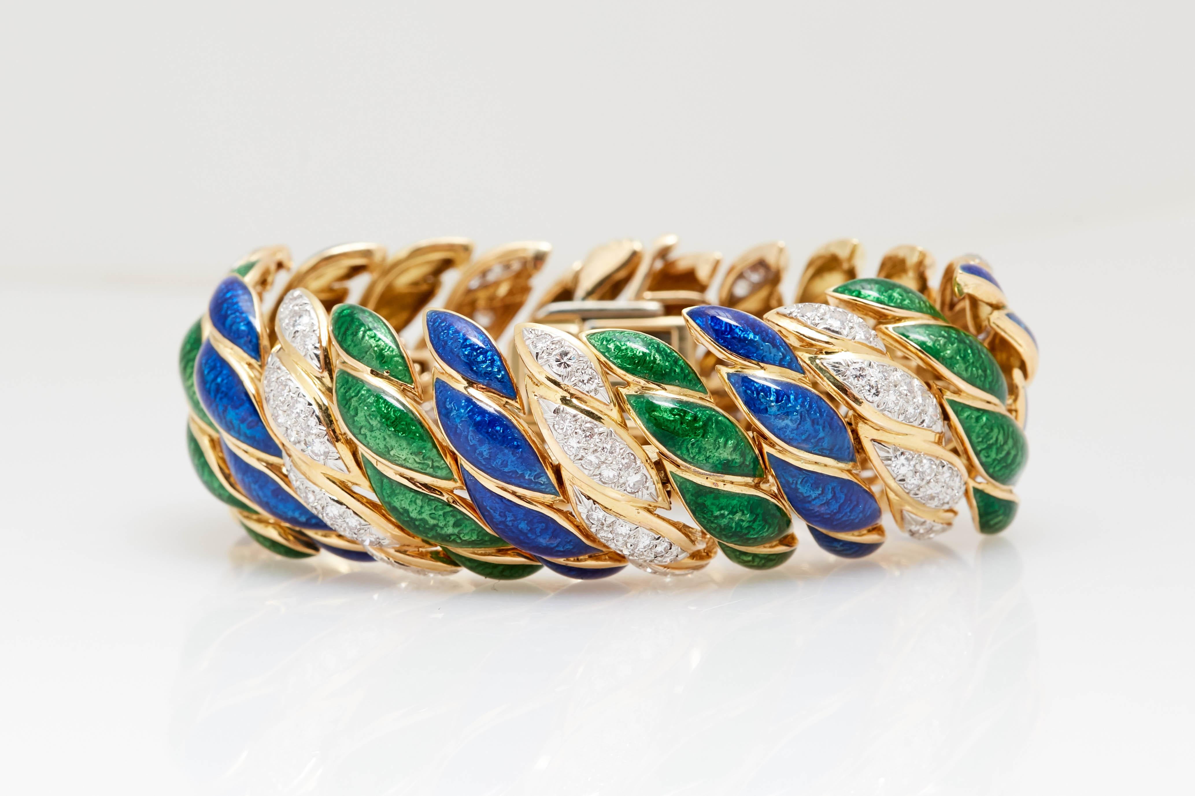Un large bracelet David Webb en or, platine, émail bleu et vert, et diamants.
Composée de paires de maillons de ruban bombé bleu et vert à motifs, soulignés d'or, espacés par des maillons de ruban en or bombé sertis de 154 diamants ronds en platine