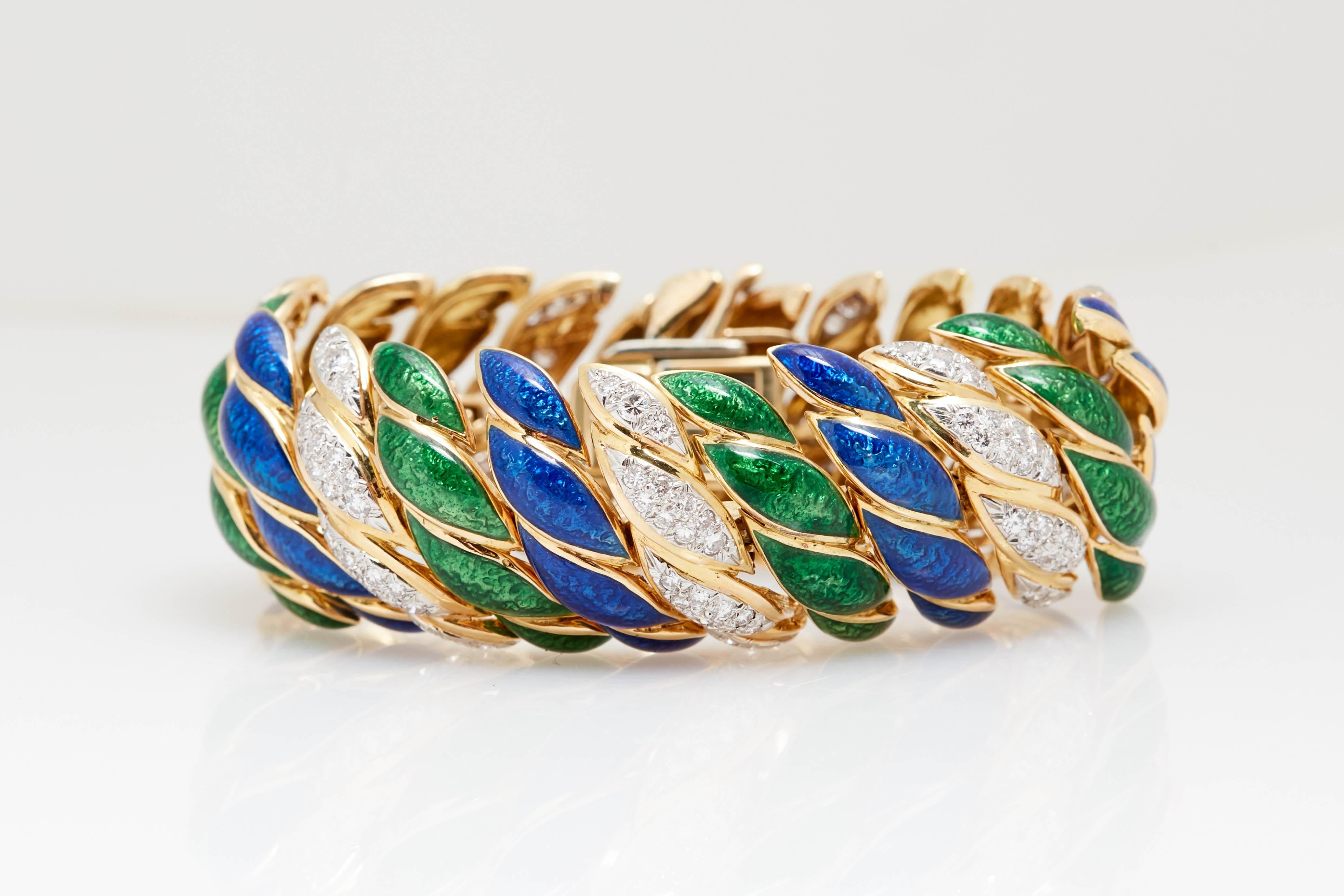 A wide David Webb gold, platinum, blue and green enamel, and diamond bracelet.
Composed of pairs of patterned blue and green bombé ribbon links, outlined in gold, spaced by bombé gold ribbon links set with 154 platinum-set round diamonds