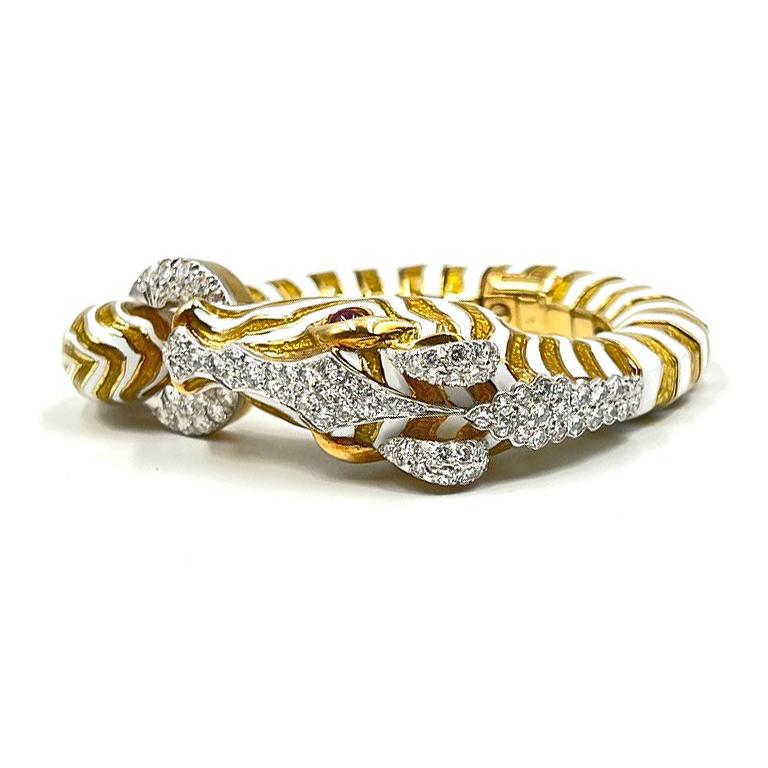 Iconic vintage stylized Zebra bangle bracelet, in white striped enamel enhanced by pavé-set round diamonds with cabochon ruby eyes. Handcrafted in 18k yellow gold and platinum. 82 diamonds weighing ~3.40 total carats (E-F color, VVS1-VVS2 clarity).