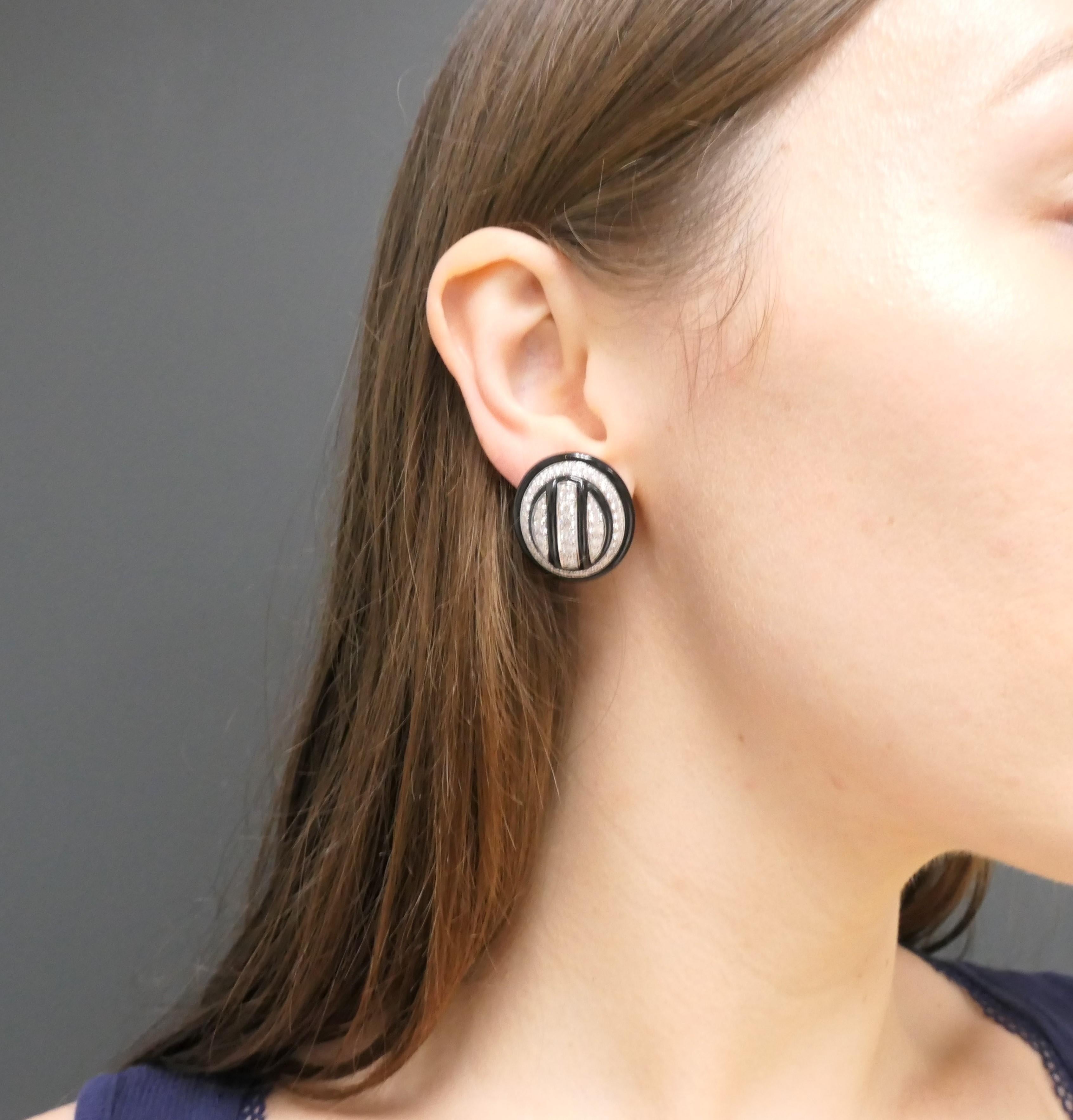 A spectacular pair of David Webb enamel earrings, made in 18 karat gold and platinum, featuring diamond. 
These oval-shaped earrings feature a domed design encrusted with diamonds and accented by two vertical enamel stripes. The striking