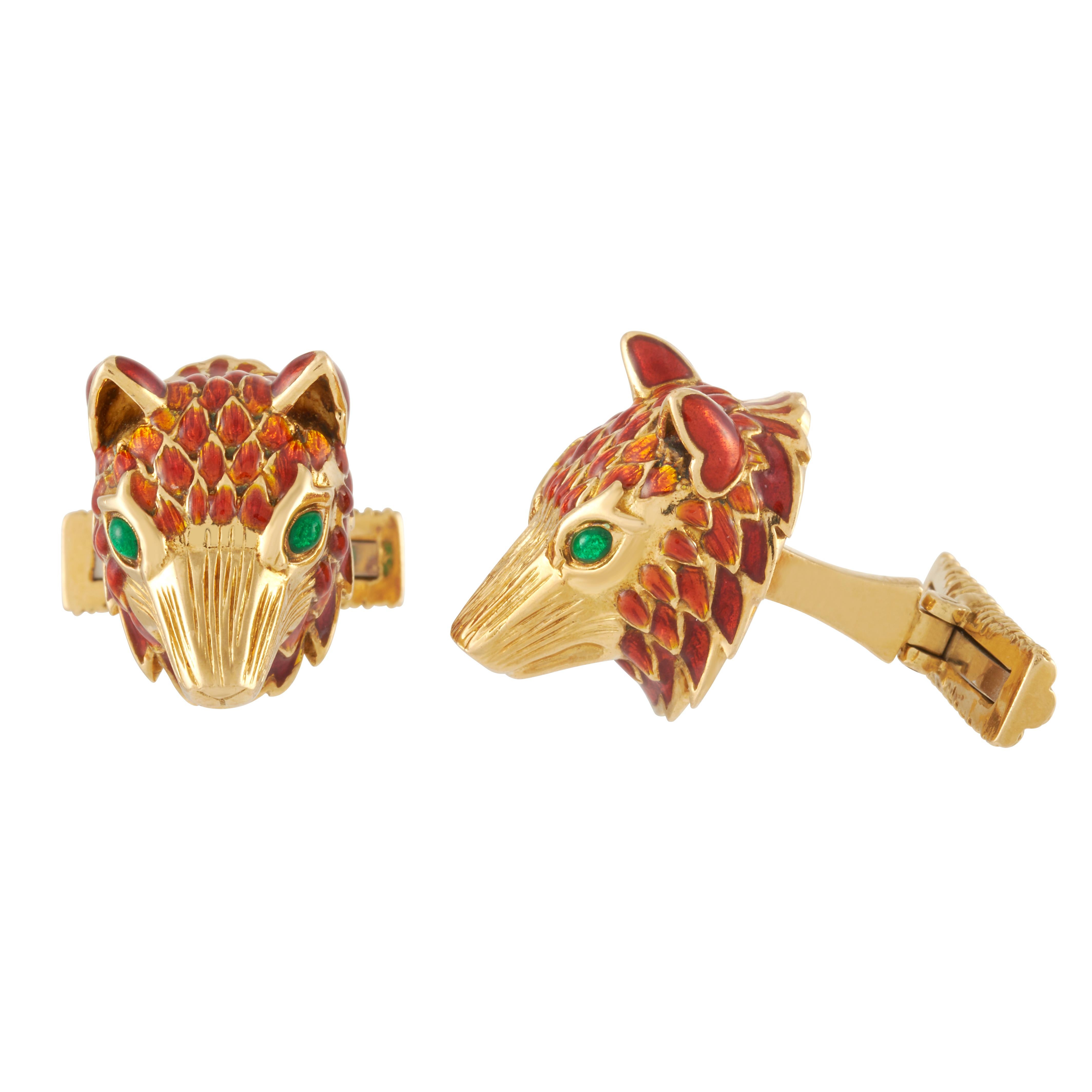 David Webb enamel fox head cufflink and tie tack set in textured 18k yellow gold, accompanied by a David Webb certificate of authenticity.  

The foxes in these pieces are a brownish-red enamel, with bright green enamel eyes. 

The cufflink fox