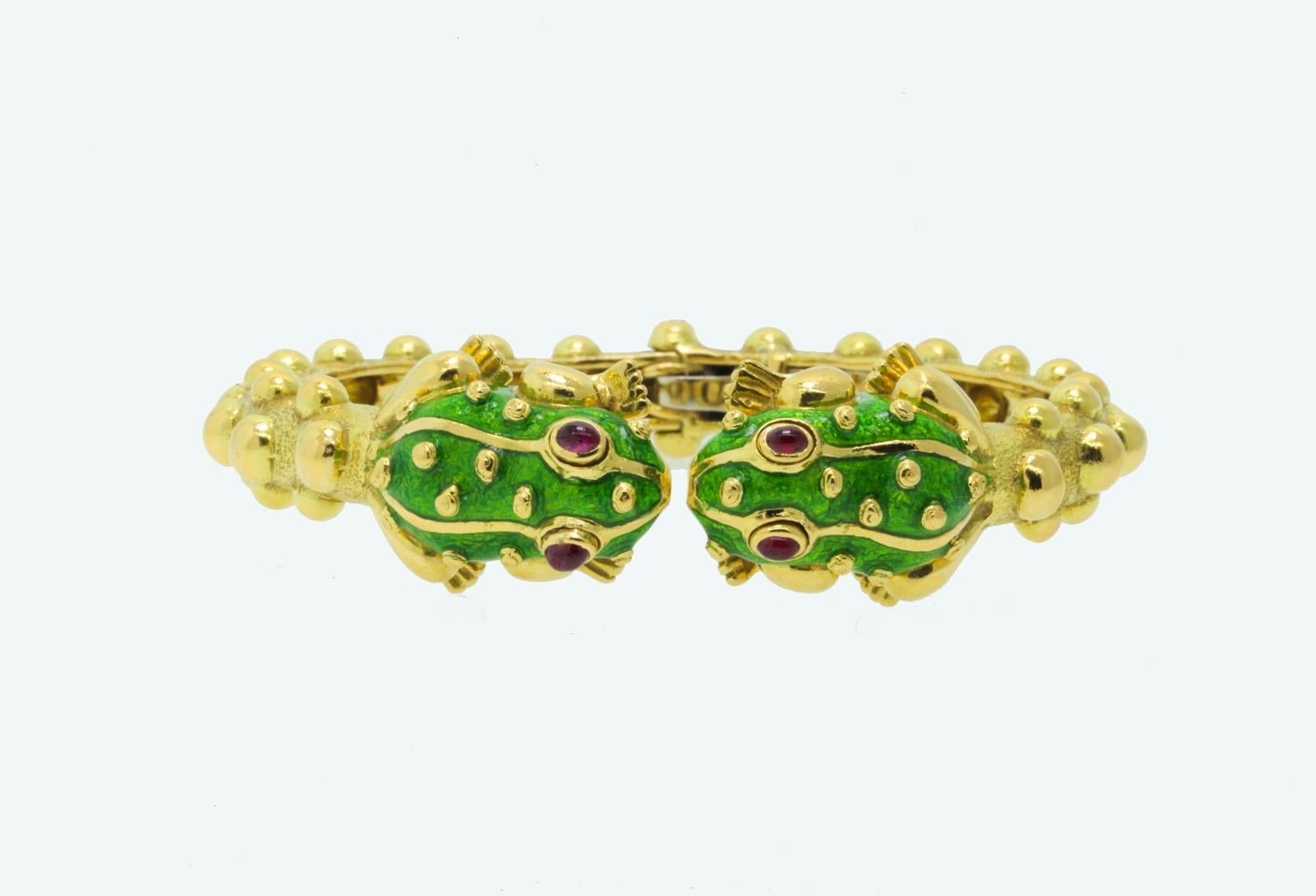 Vintage David Webb.  One of the most iconic characters of the Kingdom Collection,  two green enamel Frogs with cabochon Burma Rubies eyes.  This whimsical 18KT gold  bangle has bumps all around which ties in with the bumps on the frogs.  Circa 1970s 