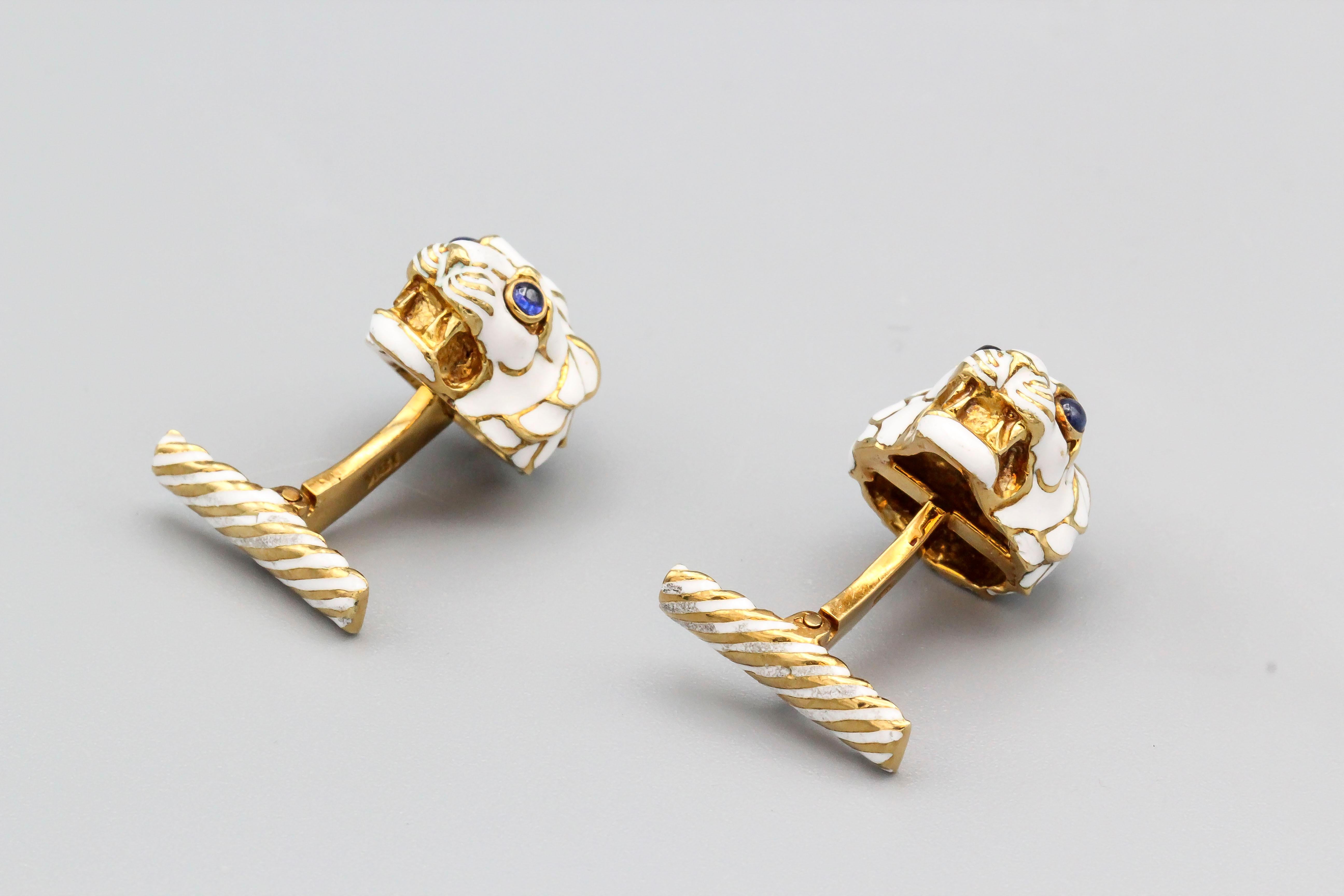 Fine pair of cabochon sapphire and 18K yellow gold cufflinks by David Webb. They resemble a lion's head, with cabochon sapphire as eyes and white enamel.

Hallmarks: Webb, copyright, 18K.