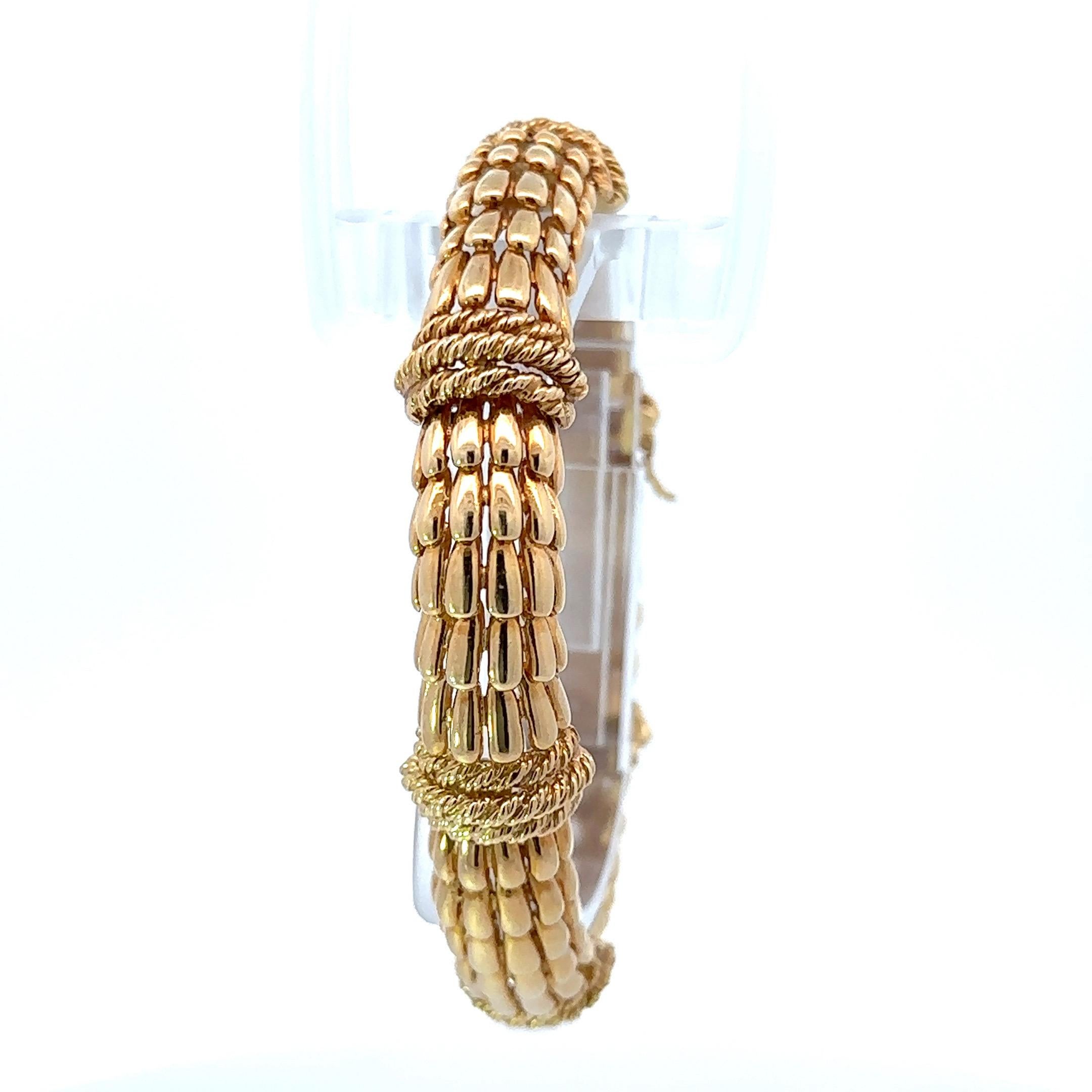 
Discover the timeless beauty of this exquisite David Webb bracelet, a true embodiment of vintage 1970s elegance. Expertly crafted from 18kt yellow gold, this stunning piece showcases a mesmerizing fishscale design, accented with intricate rope work