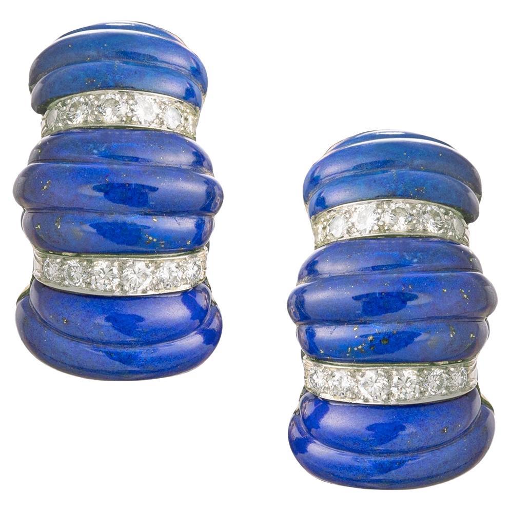 Boucles d'oreilles clips demi-hoop David Webb des années 1970 en or jaune 18 carats, chacune présentant des sections de lapis-lazuli cannelées et sculptées, séparées par des rangées de diamants de taille ronde sertis dans du platine. 48 diamants