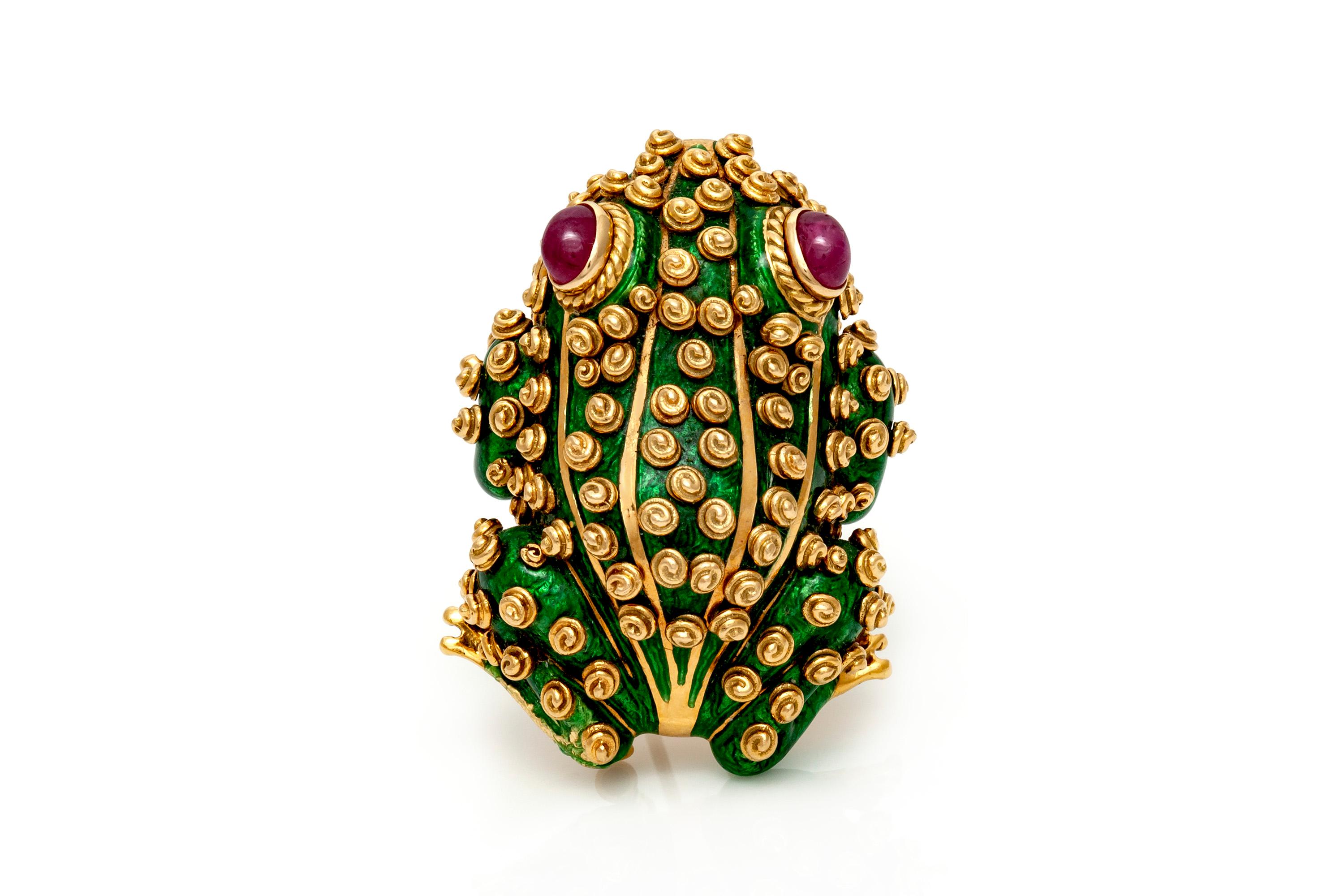Frog brooch, finely crafted in 18k yellow gold with a green enamel featuring sharp body lines and spiraled dots for a lifelike appearance. Eyes are first surrounded by a rope border with perfectly matched, bezel set cabochon rubies. Finished with a