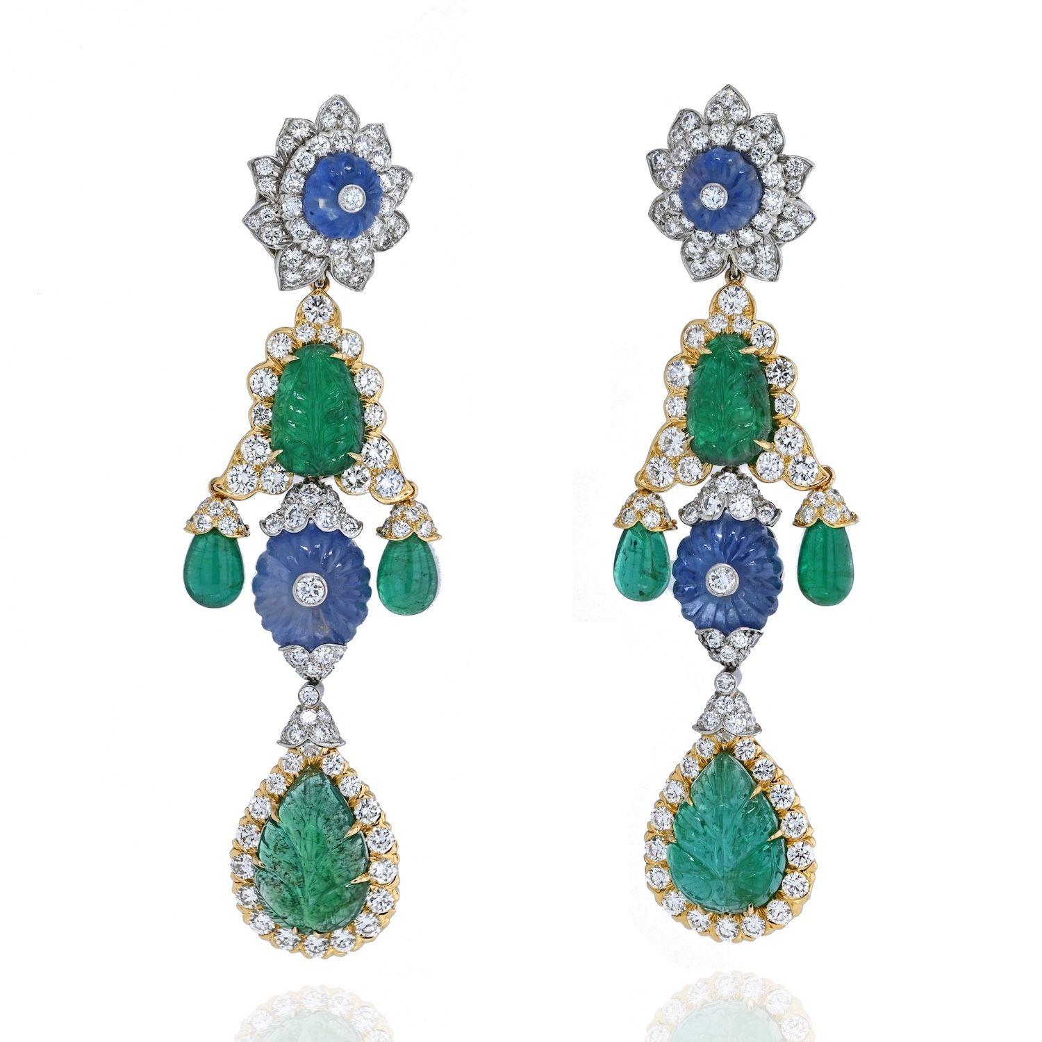 An impressive pair of earrings designed by David Webb. Easily converted from day-to-night, the earrings feature two detachable drops. 
Crafted in 18 karat yellow gold and platinum, the earrings center on carved emeralds, carved sapphire fluted