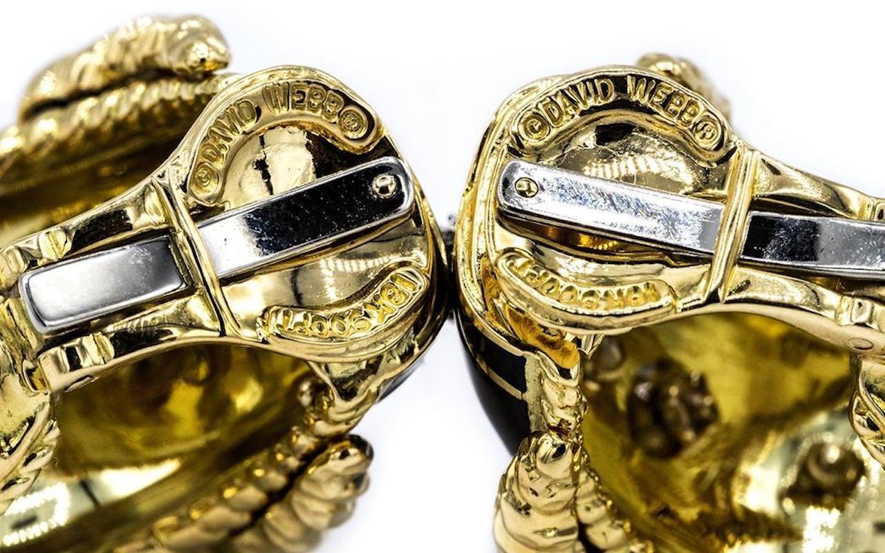 Brilliant-cut diamonds, white enamel, 18K gold, and platinum.

18k gold and platinum buckle earrings by David Webb, set with black enamel and approx,. 0.50ctw in H/VS diamonds.
