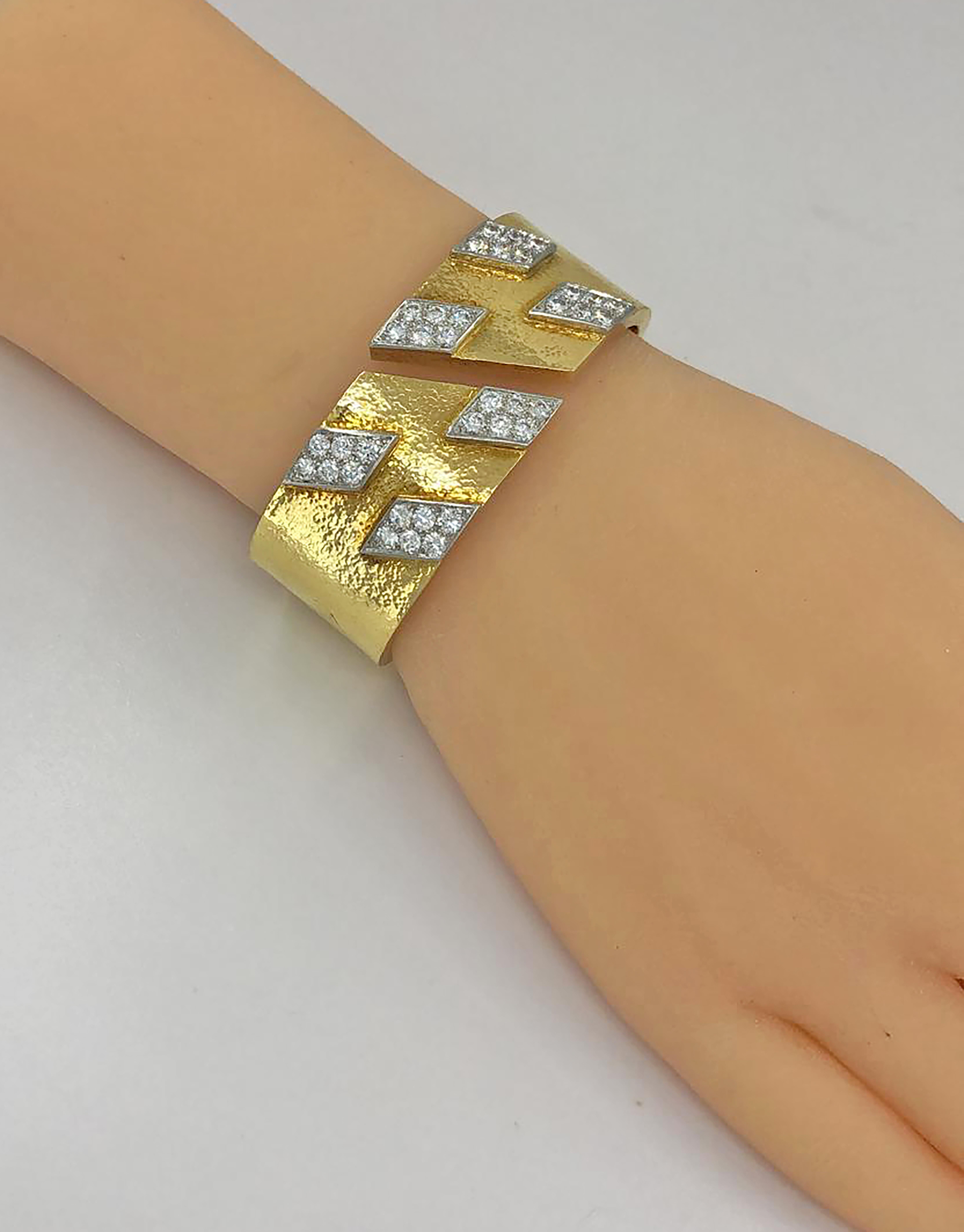 David Webb Diamond Spring Cuff Bracelet in 18k Yellow Gold and Platinum.

A David Webb wide spring bracelet textured with emblematic tactile gold, adorned with six slanted geometric panels of platinum set with diamonds. The bracelet appears heavy