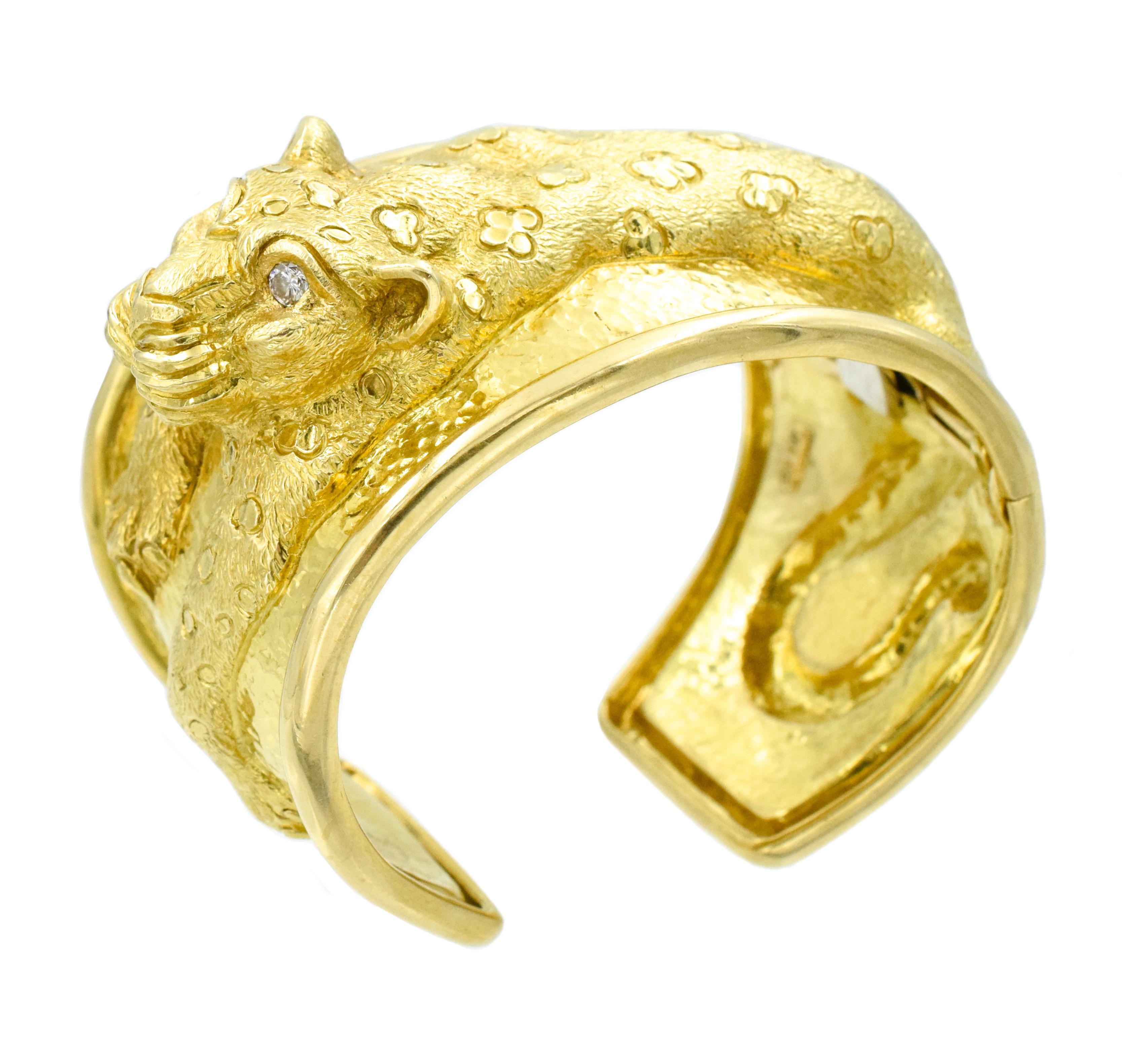 David Webb 18k Gold and Diamond Leopard Bangle Cuff This bracelet has leopard motif created in gold repoussé drapes over the hinged cuff, its eyes set with round brilliant-cut diamonds; 
signed Webb, no. JA60
113 grams;
 Circumference: 6 inches