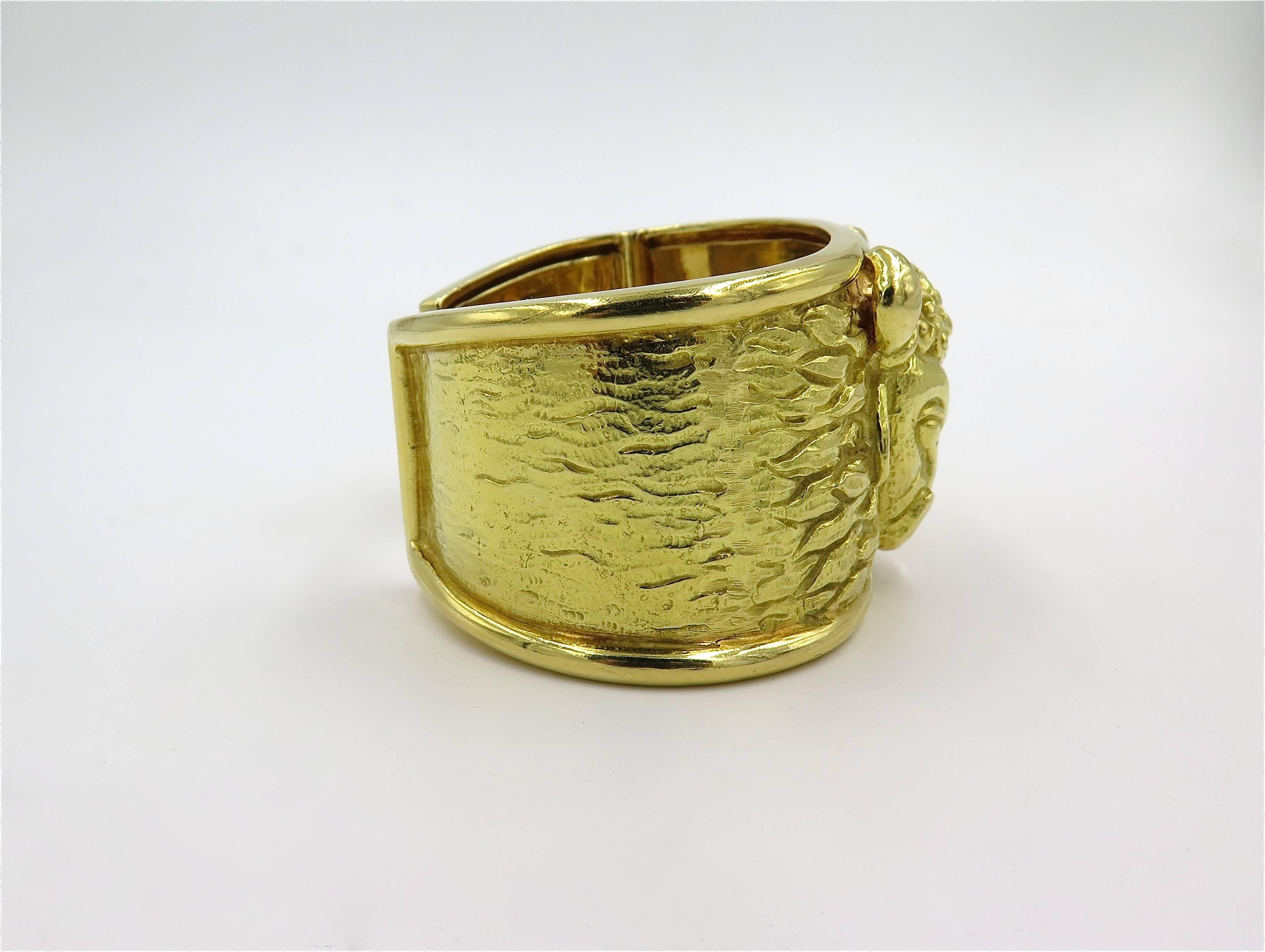 An 18 karat yellow gold cuff bracelet.  David Webb. Designed as a wide textured hinged cuff, centering a bull’s head. Width of bracelet is approximately 1 1/2 inches, inside measurement is approximately 6 1/4 inches, diameter is approximately 2 1/4