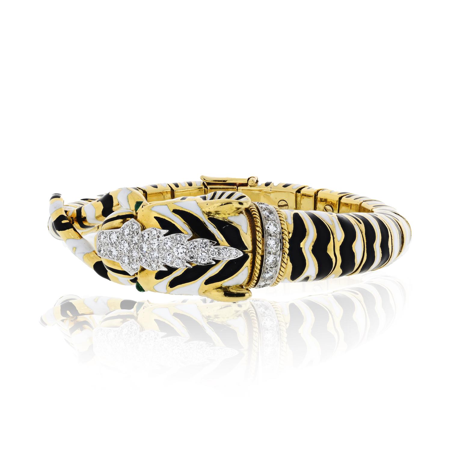 Fine and unusual diamond, emerald, platinum, and 18K yellow gold, bangle bracelet by David Webb. It resembles a tiger head, with cabochon emerald eyes and black enamel stripes, adorned with high-grade round brilliant cut diamonds set in platinum