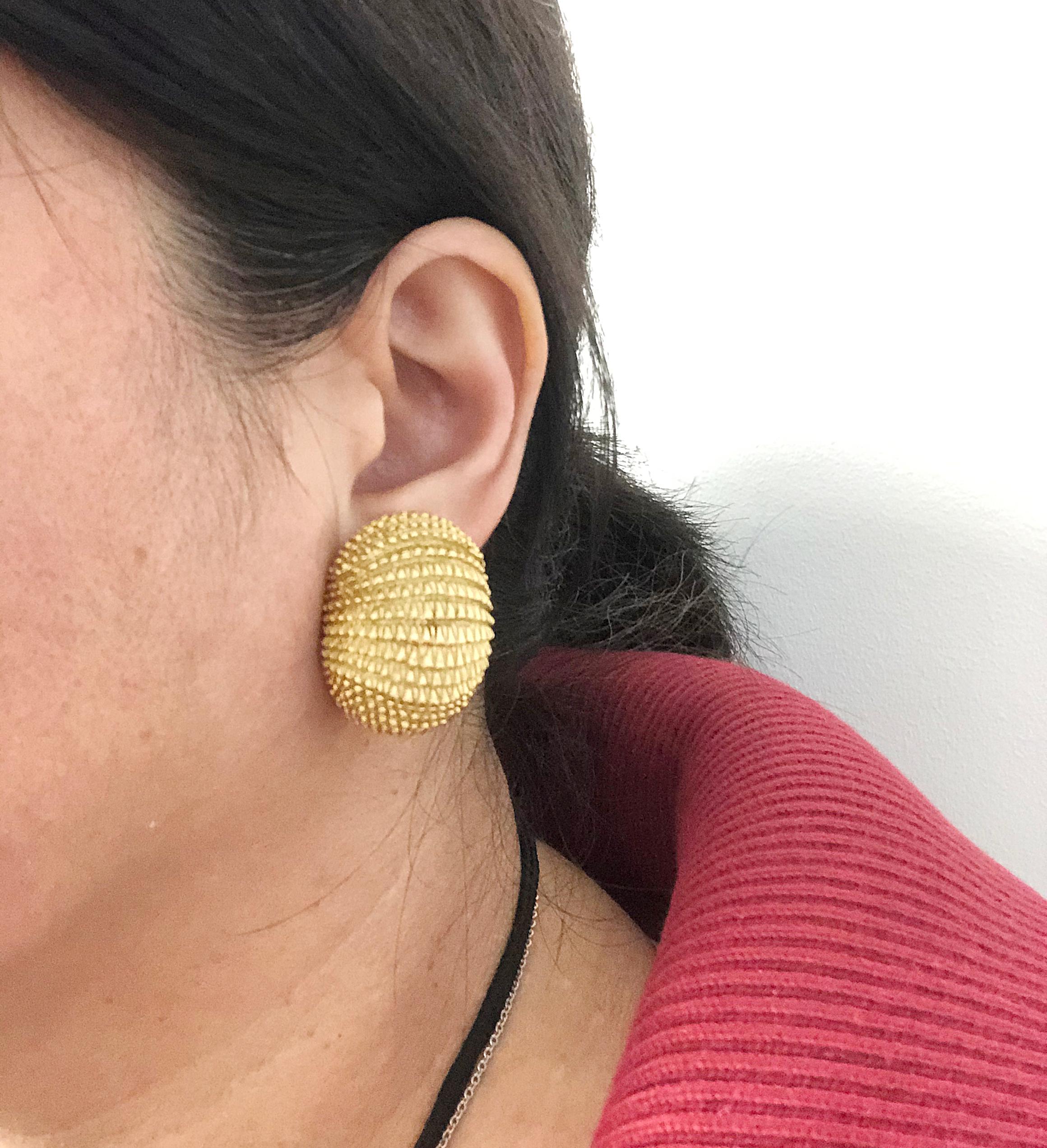 A stylish pair of earrings by David Webb, each comprised of 18k yellow gold set in a unique bombe design, with intricately crafted textured details. 

Measures approx. 1.22″ in length by 1.0″ in width, 0.55″ in height
Stamped “David Webb”; circa the