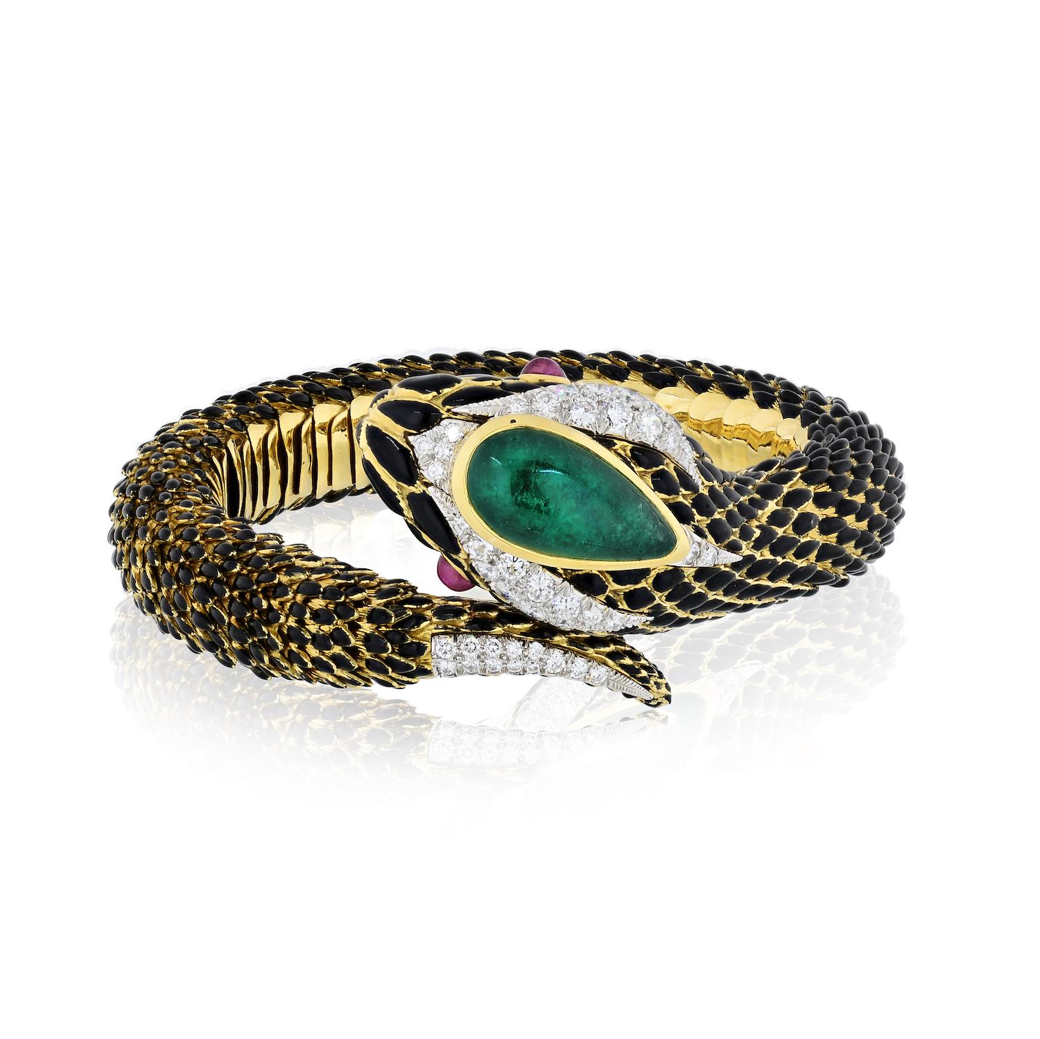 David Webb 18K yellow gold bracelet crafted in a form of a snake with a beautiful green cabochon emerald atop her head. Red ruby cabochon eyes and lovely round brilliant cut diamonds framing her head and tail add a touch of sparkle for an extra