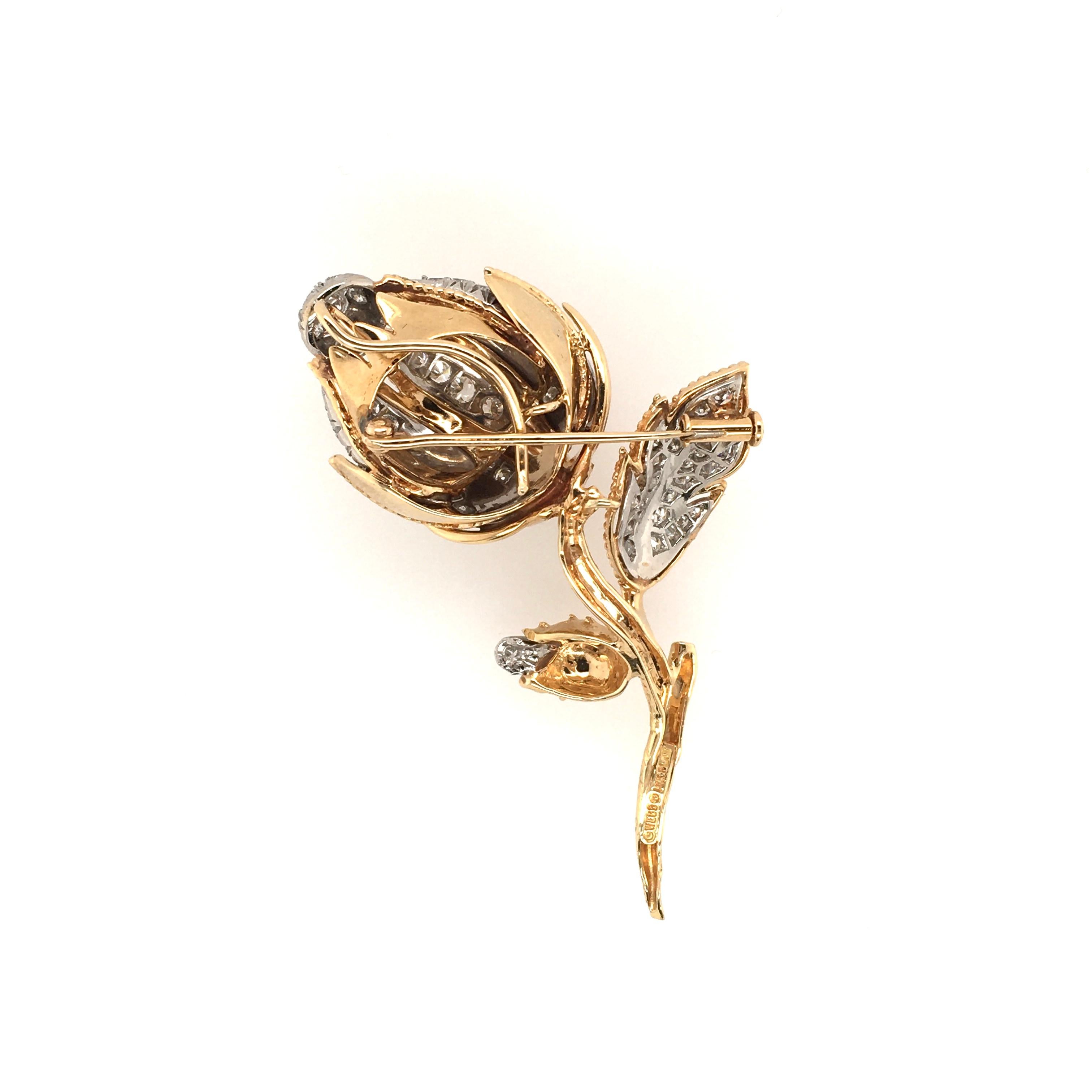 An 18 karat yellow gold, platinum and diamond brooch. Circa 1960. David Webb, Designed as a textured and polished gold rose, enhanced by pave set diamonds. Sixty three (63) diamonds weigh approximately 3.00 carats, Length is approximately 2 3/4