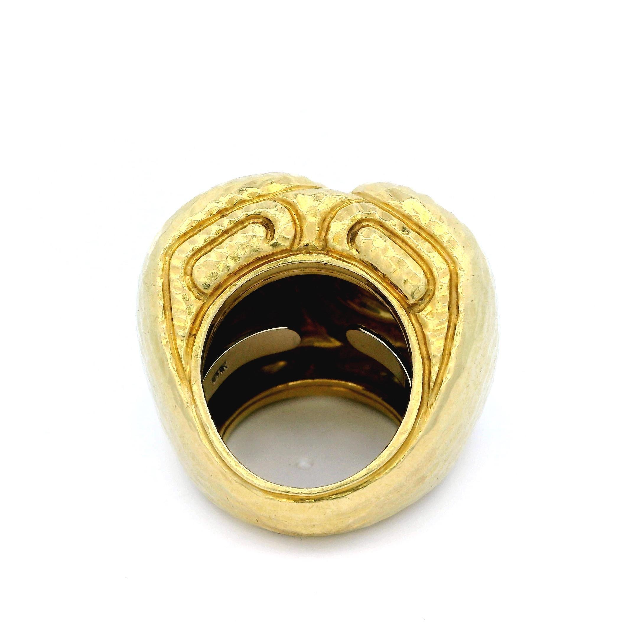 Ein auffälliger Goldring von David Webb, der 1980 in den Vereinigten Staaten von Amerika hergestellt wurde. Das Design zeigt kühne, wirbelnde Muster, die sorgfältig gehämmert wurden, um eine strukturierte Oberfläche zu schaffen. Mit einem Gewicht