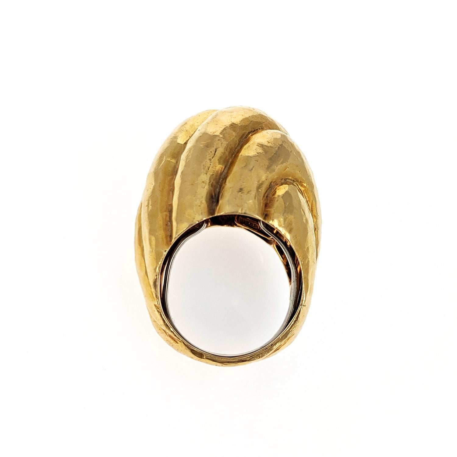 An 18k yellow gold ring, in a hammered metalwork texture, with a fluted, high bombe design. Signed Webb. Size 7.5.