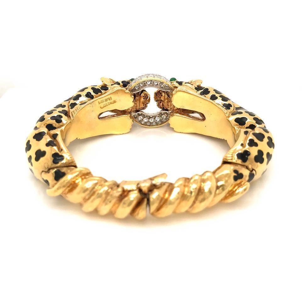 David Webb Gold Vintage 18k Yellow Leopard Double Head Pave Diamond Bracelet

18K yellow gold and platinum Double Leopard Bangle Bracelet with Emerald Eyes and Black Enamel Spots biting a Pave Diamond Ring, signed David Webb. The four emeralds are