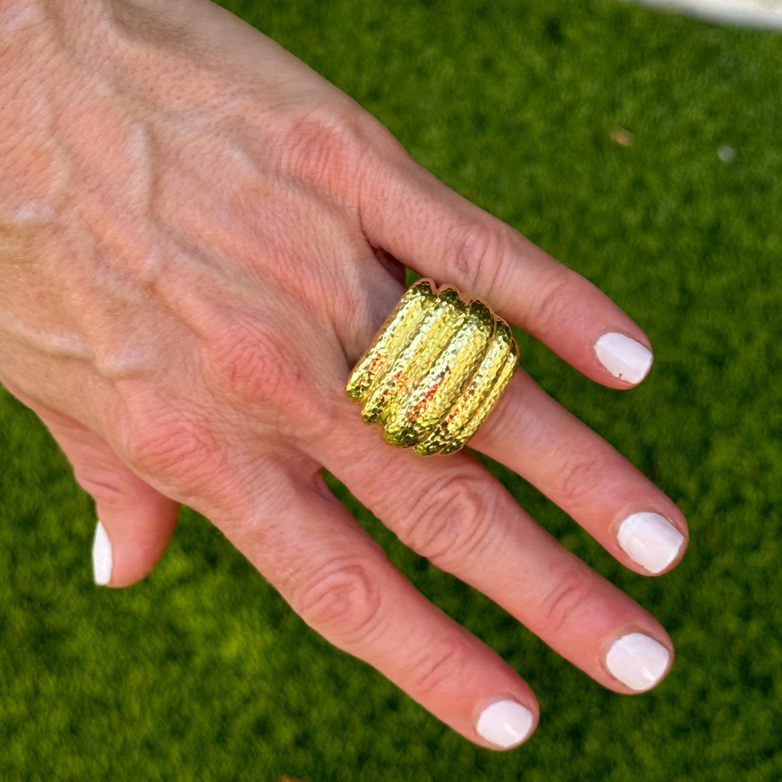 Audaz e inconfundiblemente lujoso, este anillo martillado de oro amarillo de 18 quilates de David Webb muestra la artesanía y el diseño escultural característicos de la marca. La sustancial parte superior mide aproximadamente 25 x 25 mm con una