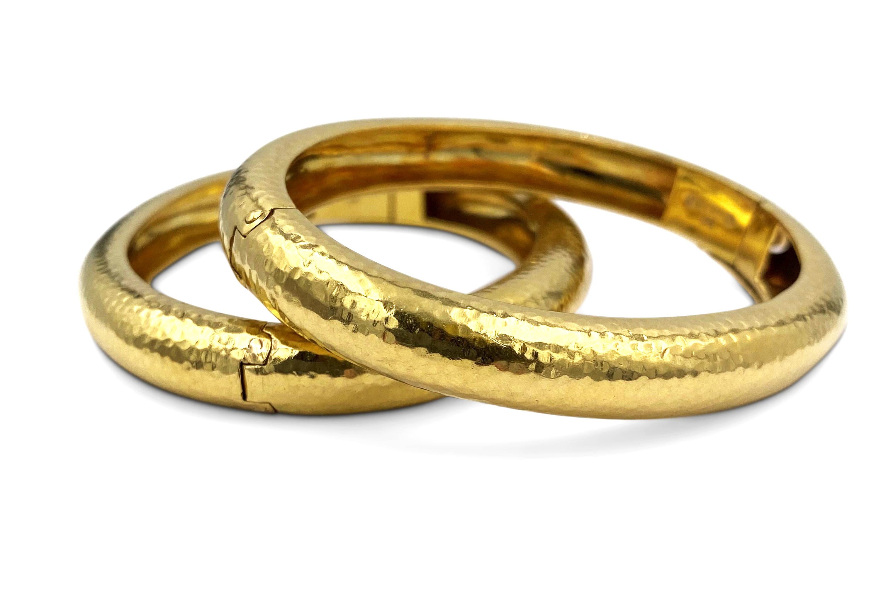 Pair of authentic David Webb hammered gold bangles made in 18 karat yellow gold.  The bracelets are 2 1/4 inches in diameter and can fit up to a size 5 1/2 wrist.  Signed Webb, 18K.  Bangles do not come with original box or papers. CIRCA 1970