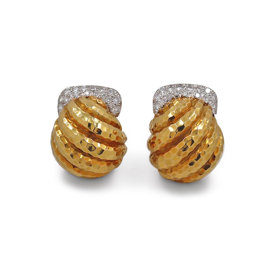 Authentic David Webb ear clips crafted in 18 karat yellow gold and platinum. Each earring is set across the top with sparkling round brilliant cut diamonds of an estimated 1.48 total carats for the pair. The hammered gold is artfully arranged in a