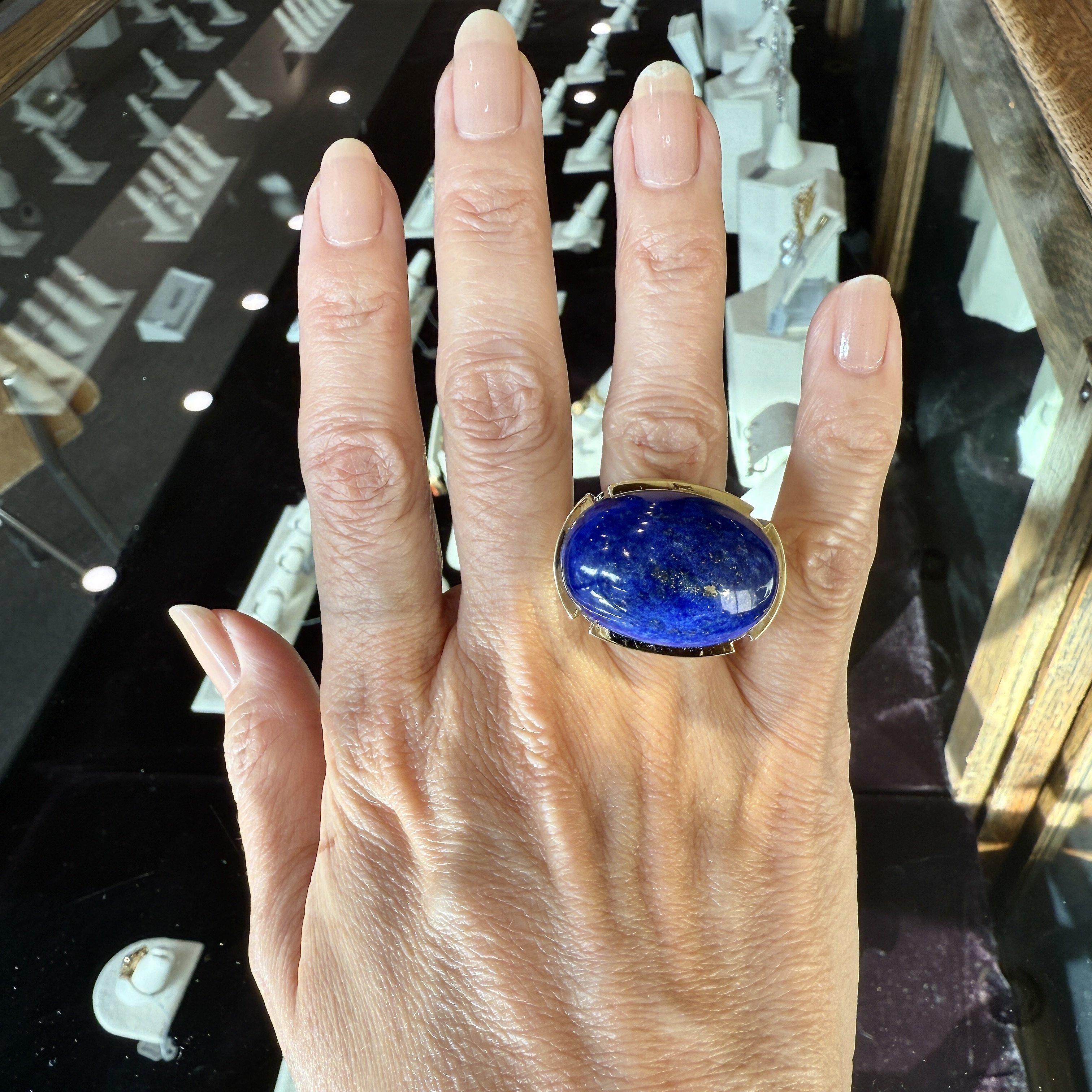 This Vintage David Webb Lapis Cabochon Cocktail Ring is from the 1960’s.
The Lapis is Stunning and Has Beautiful Gold Streaks & Specks.
It is Crafted in 18KT Yellow Gold.
The Top of the Ring measures 29mm x 22mm and it Sits 17mm above the