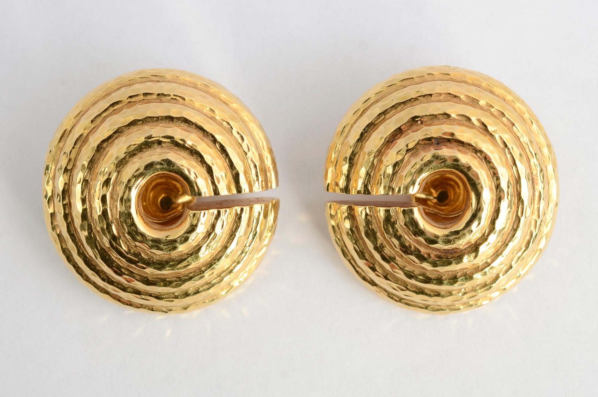 Bold earrings by David Webb of 18 karat hammered gold. They consist  of five concentric circles with an open center and a horizontal open slice that can be worn close to the face or to the back.  The earrings are 1  1/4 inches in diameter. Clip