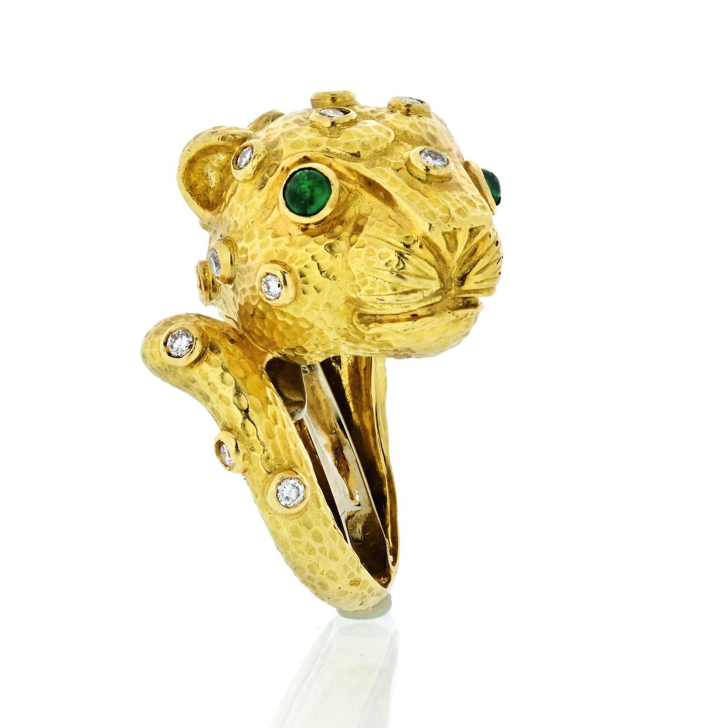 The chic David Webb lion ring is not to be taken lightly featuring full-cut round diamonds of an estimated 1.10 carats set in 18k white gold, accented with cabochon green emeralds and signature hammered finish applied on 18k yellow gold. Completed