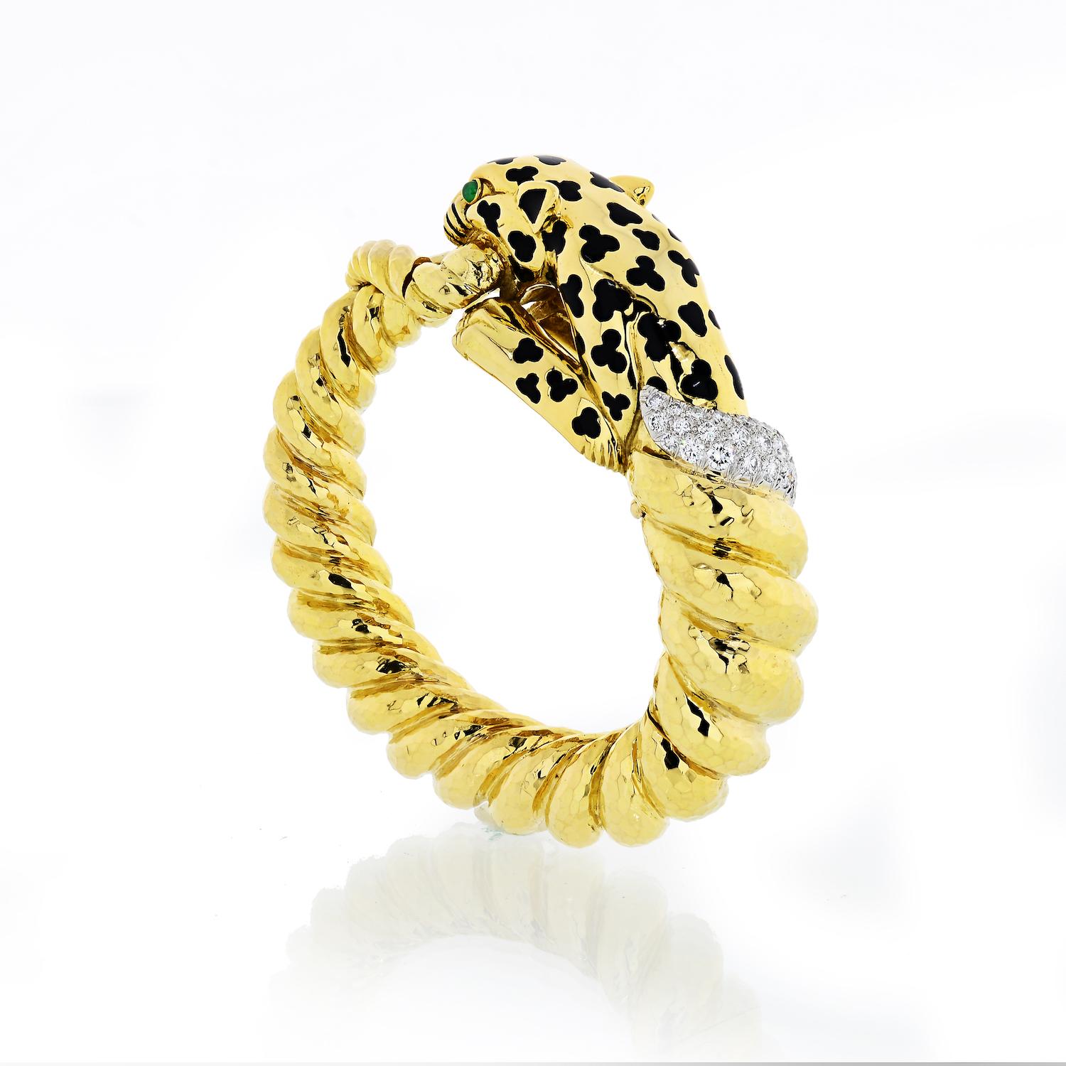David Webb Yellow Gold Leopard designed as a twisted bangle bracelet, decorated with black enamel spots, cabochon emerald eyes, and pavé-set diamonds.

The Leopard bracelet is crafted in 18k yellow gold and platinum. 

Total diamond weight: 2.18