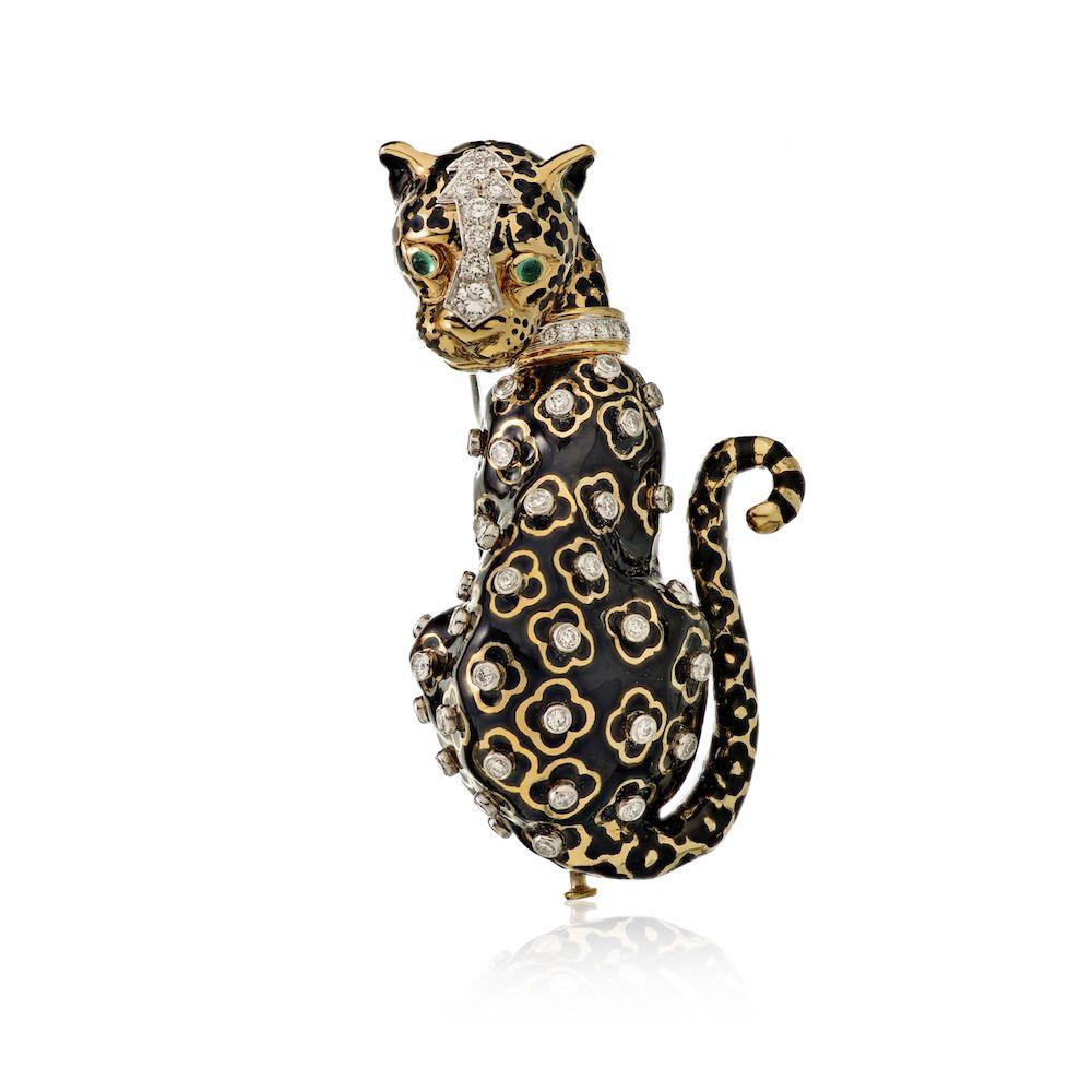 Designed as a leopard, in black enamel with gold spots enhanced with circular-cut diamonds, to the circular-cut diamond collar and cabochon emerald eyes, mounted in platinum and 18k gold. 2.5 inches long.
