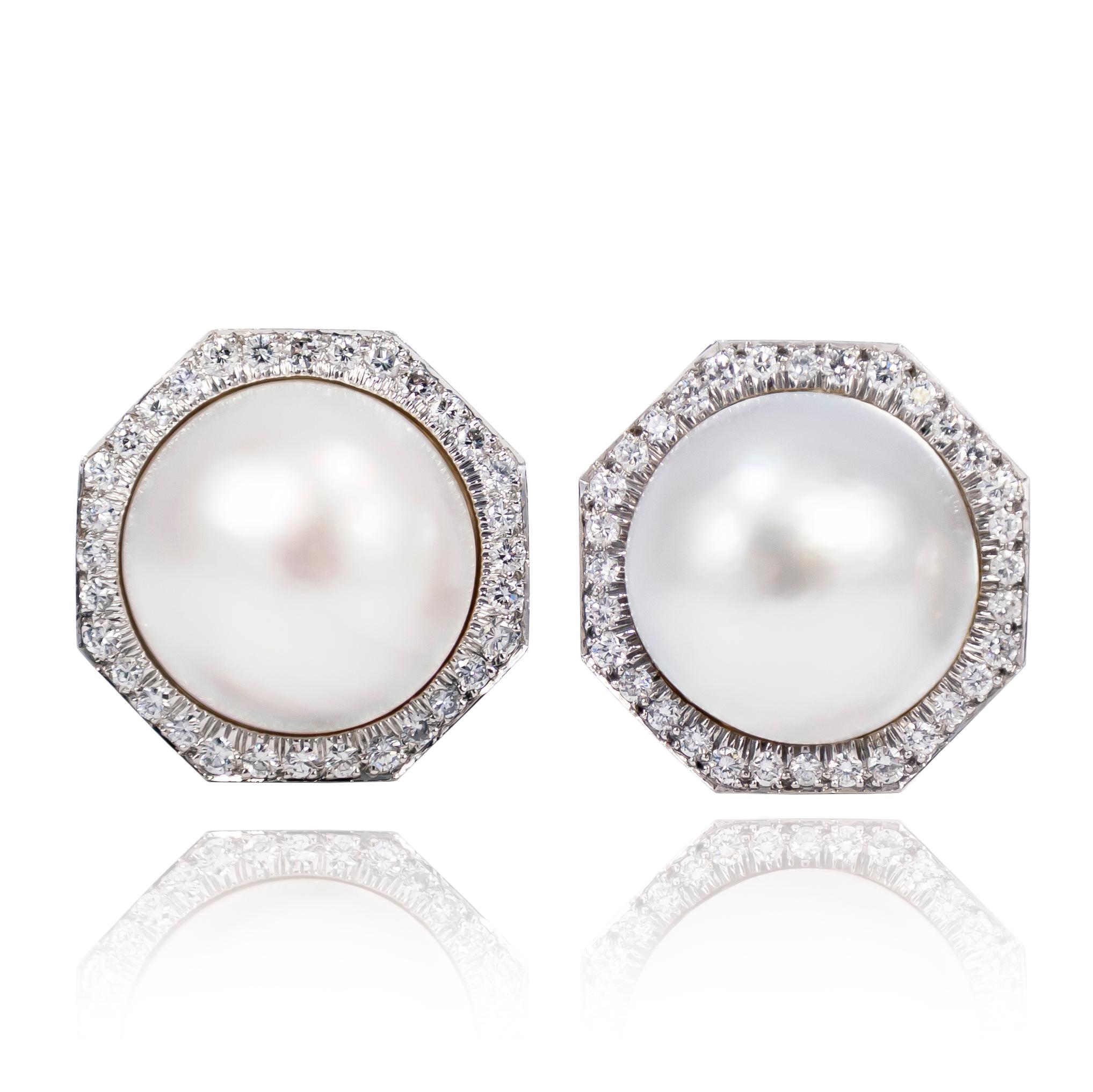 These incredibly sophisticated signed David Webb earrings feature a pair of Mabe Pearls (one with rose pink overtones, the other with cool blue overtones) and bright-cut set brilliant round diamonds. Classic with a bold aesthetic, these earrings