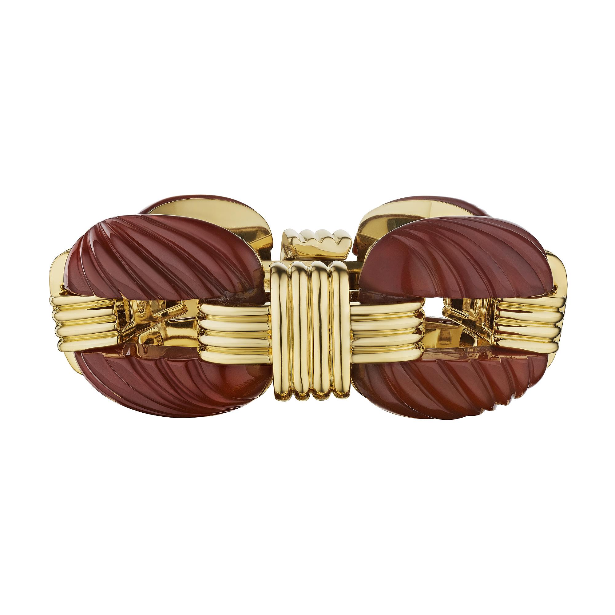 Big and bold, this David Webb modernist carnelian and gold bracelet will never let you go unnoticed.  With four oval carved carnelian twisted rope links interspersed with alternating gold crisscross links, this collectible bracelet is as sumptuous