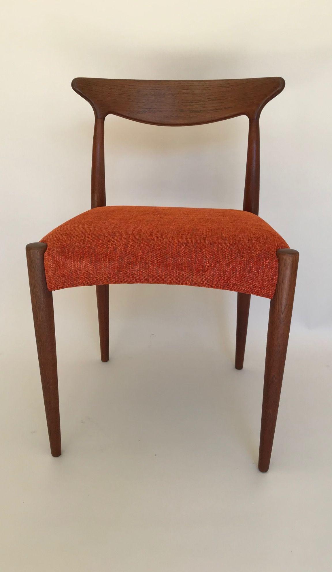 Set of four teak dining chairs designed by Arne Hovmand Olsen. Produced by Mogens Kold Denmark. All chairs are in very good condition, they have been reupholstered in a burnt orange chenille fabric.

 Makers plaque on underside of the chairs.

 
