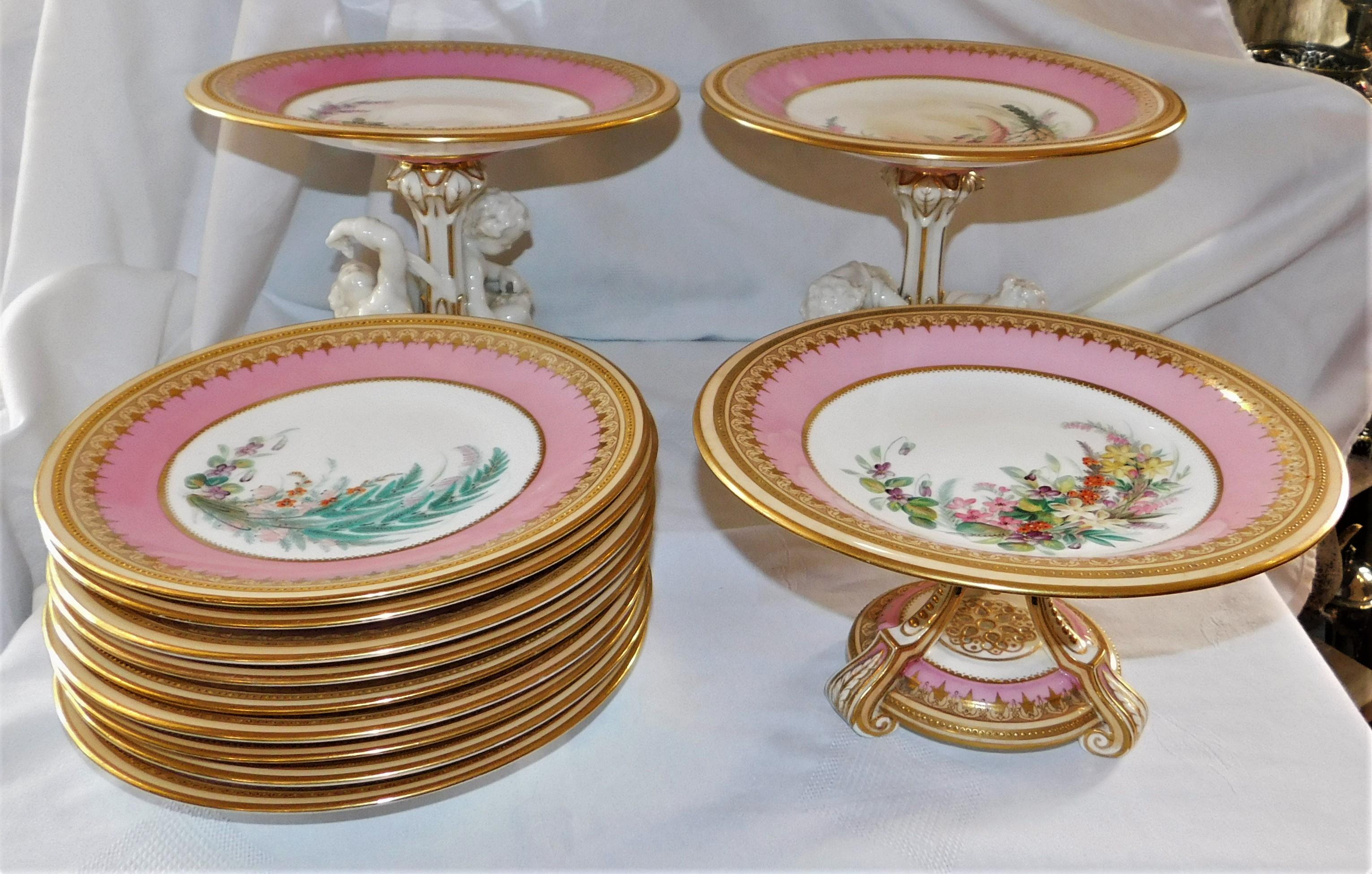 This unusual dessert service consists of nine plates and three footed compotes. Each piece is uniquely hand painted with a floral design and embellished in gold trim. The footed compotes are a brilliant addition to the grouping for serving and