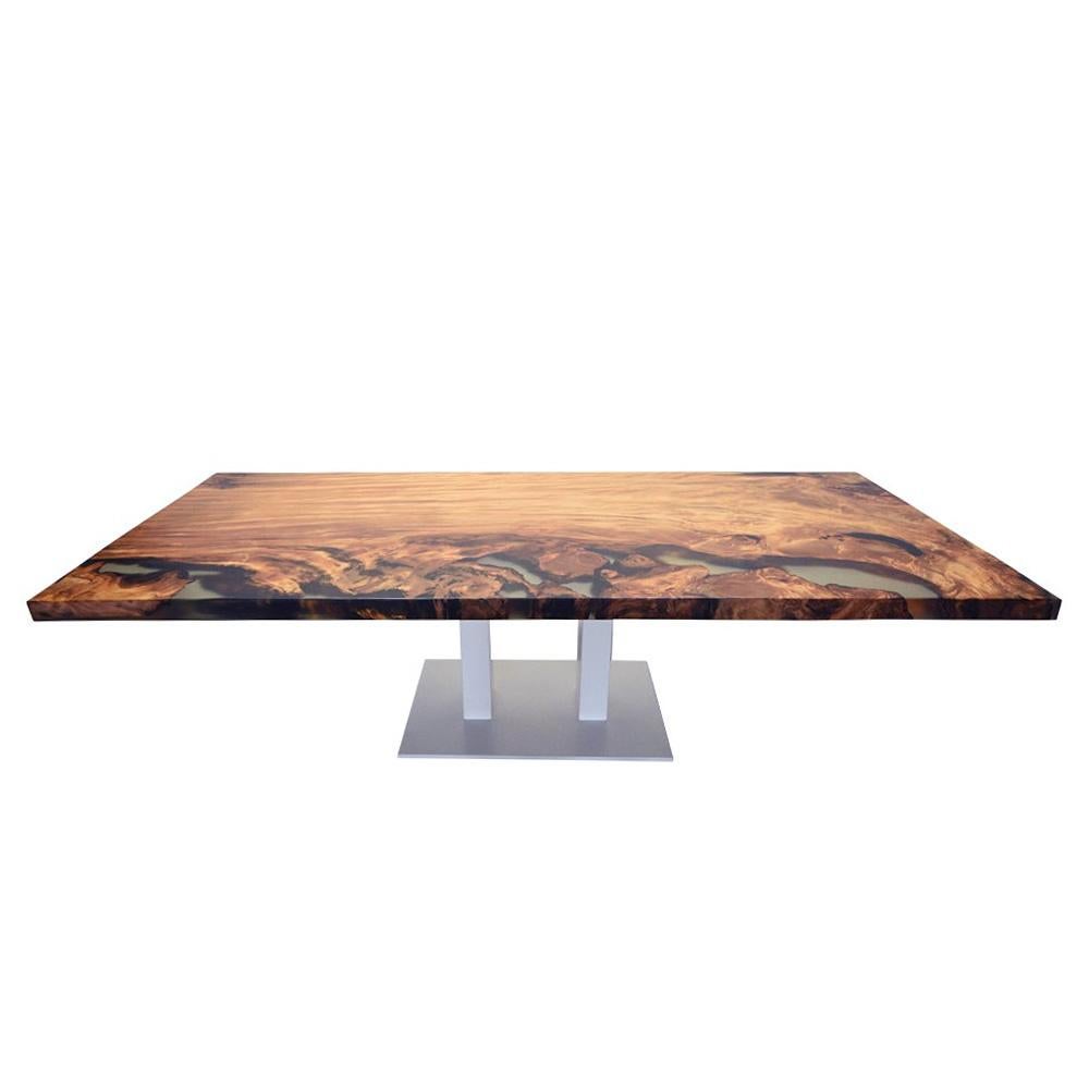 Dinning table Kauri wood with resin with solid Kauri
wood top with mix of light and dark shades and with
very strong patterns. With many high technology resin
parts on one side of the top. With precatalyzed matt
varnish finish. Steel threaded