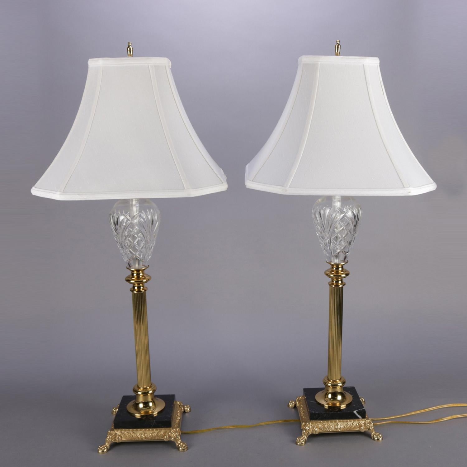 Pair of Irish Waterford Marlow regency table lamps feature cut crystal font over reeded brass Corinthian column form pedestal and seated on black marble base supported by cast brass paw foot frame, signed Waterford on shade, base and font, electric,