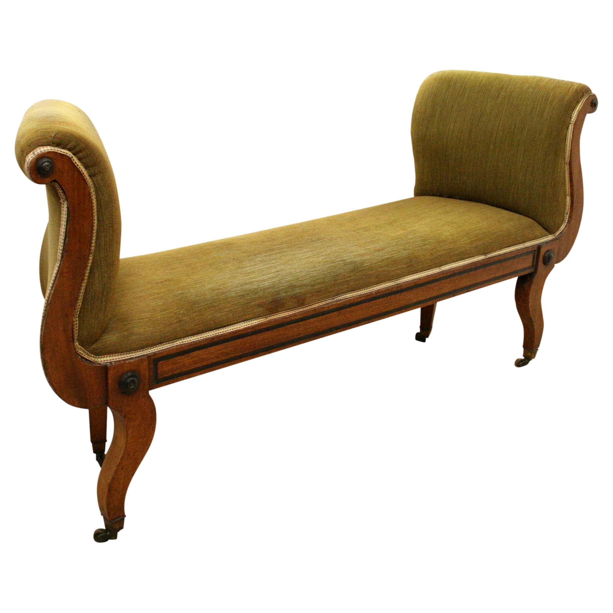 Unusual and stylish Regency period mahogany window seat. The raised curved ends are almost in the form of lyres and there is a small carved roundel at the top. There is a small recess on the fore edge giving the impression of a fielded panel, and