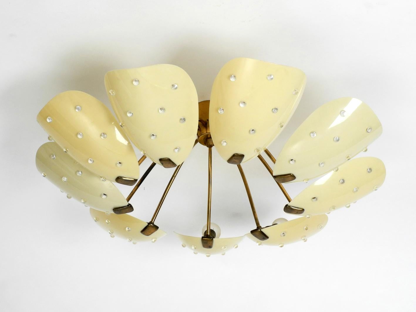Beautiful gigantic nine-arm, very rare midcentury brass chandelier with plexiglass shades.
Elaborate very high-quality design from the 1950s.
Frame, canopy and original sockets made of brass. The shades have small transparent stones as inlays.